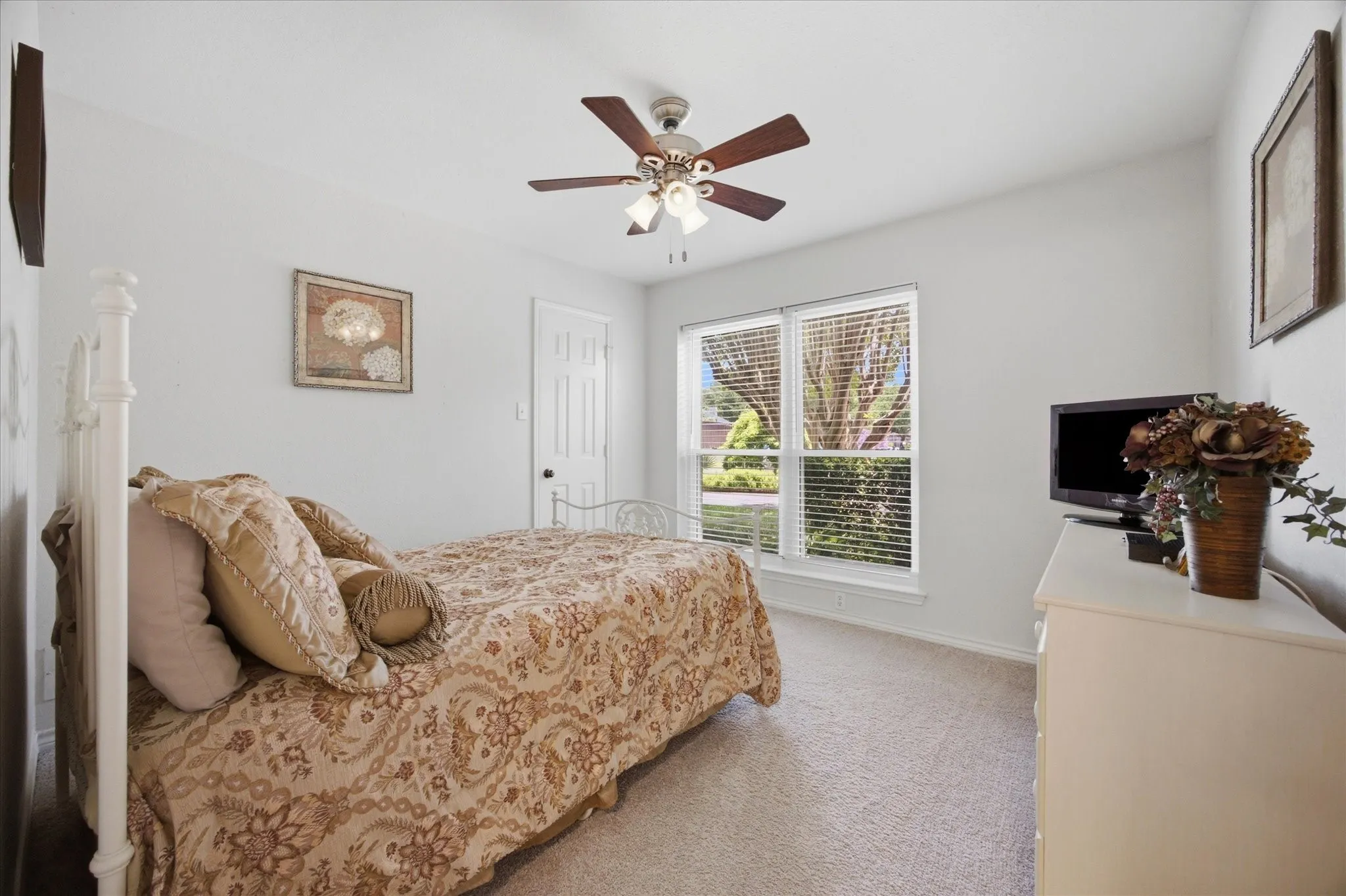 Carpeted room featuring a ceiling fan with light fixture, window with horizontal blinds, and a paneled interior door