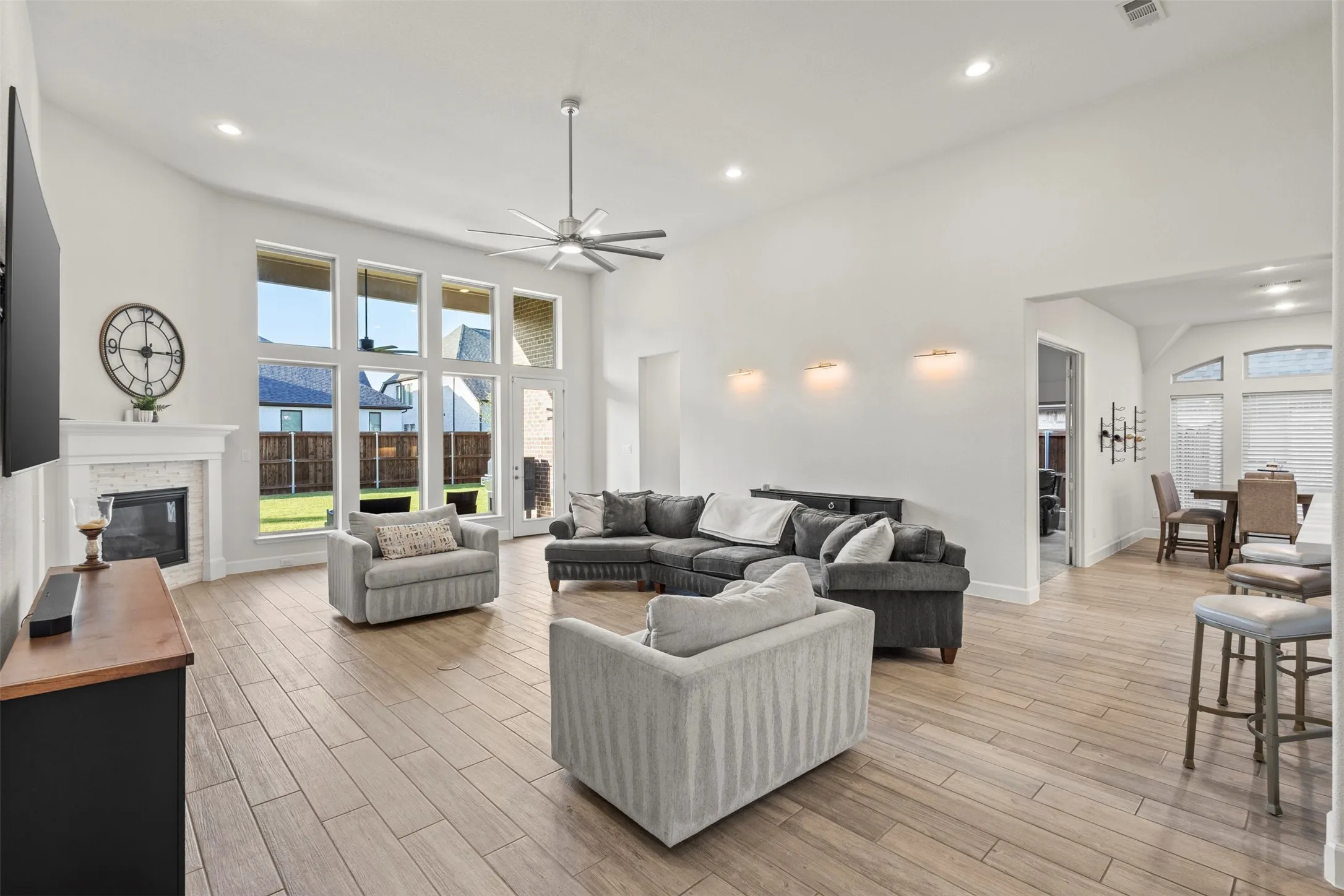 Open-concept living space featuring wood-finish flooring, a contemporary ceiling fan, and recessed lighting