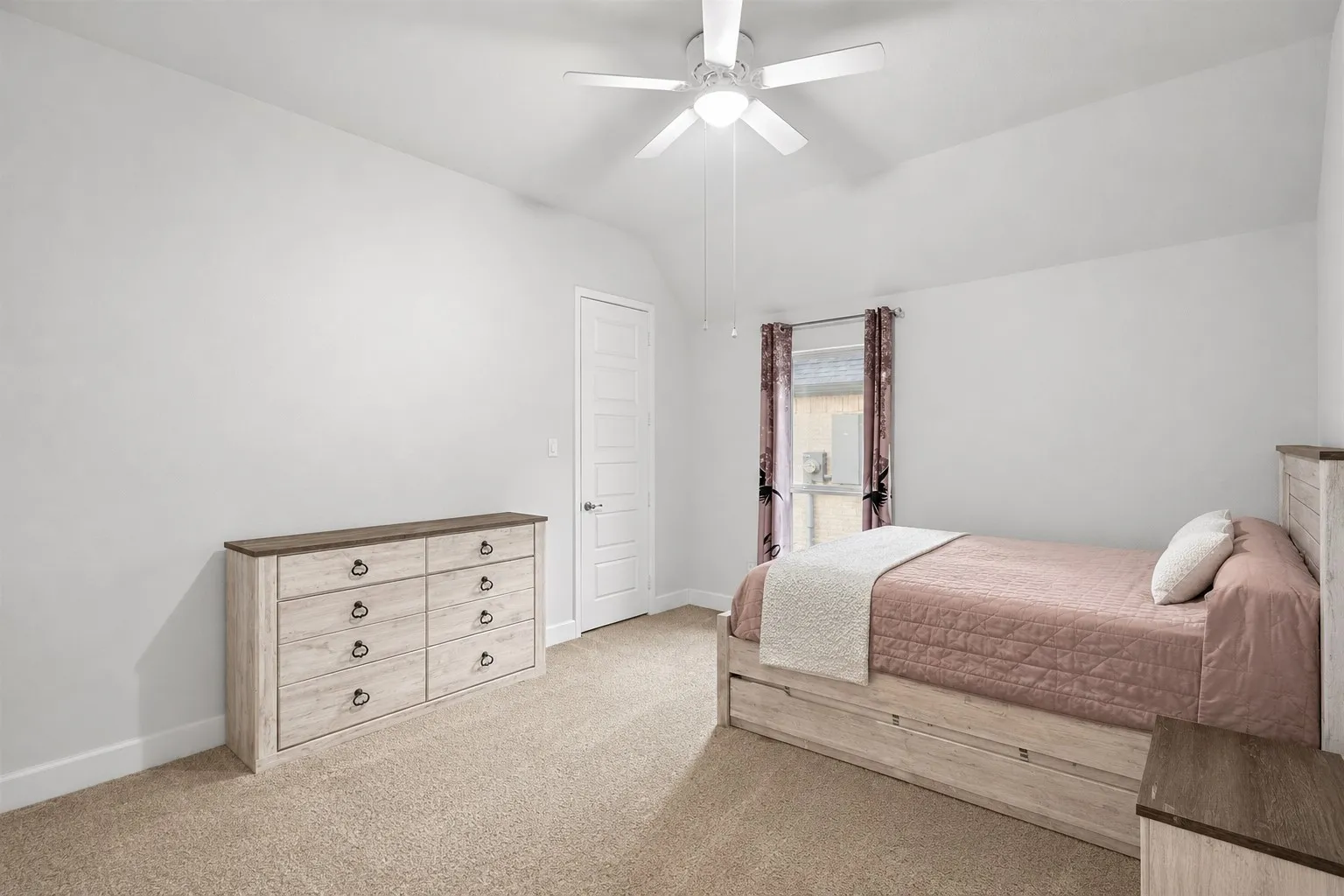 Carpeted room with a vaulted ceiling, ceiling fan, and a single window