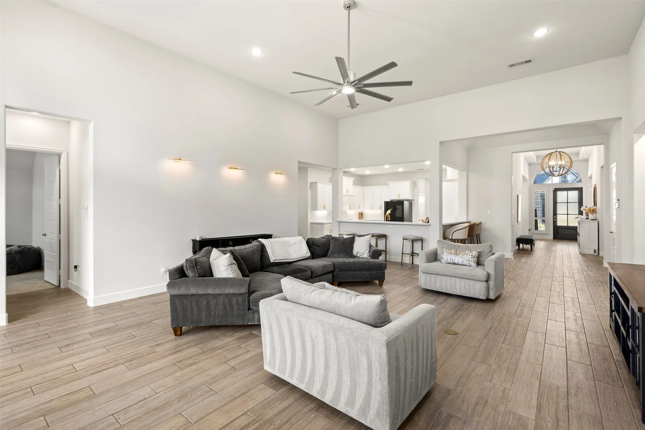 Spacious living area featuring high vaulted ceilings, wood-finish flooring, and recessed lighting