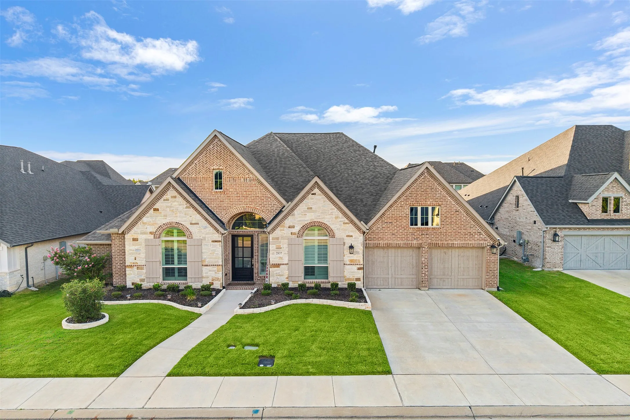 Stately brick and stone exterior with architectural shingles