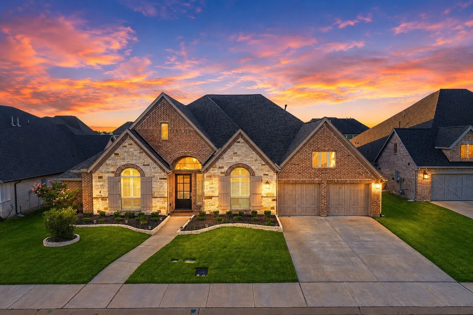 Stone and brick facade with multiple gables and dark shingle roofing