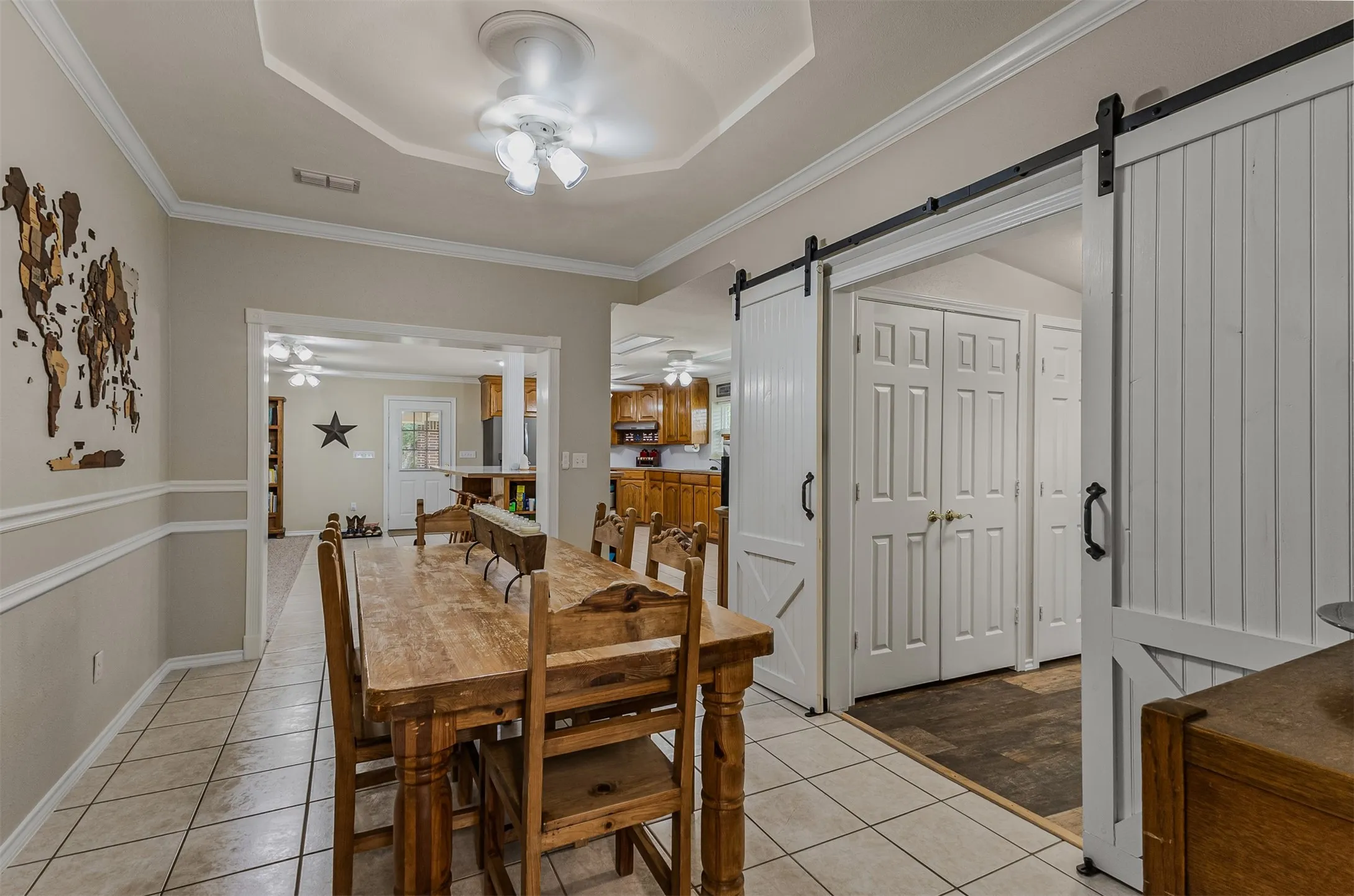 Large dining area with barn doors open to the living room and kitchen of 339 Colwell Rd in Forestburg, TX