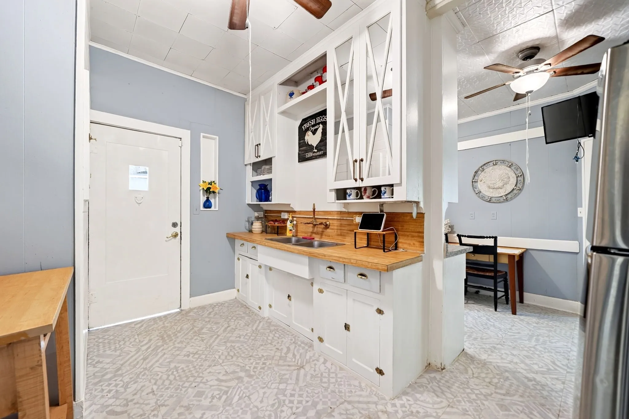 Kitchen space featuring white cabinetry, light wood-finish countertops, and a stainless steel sink