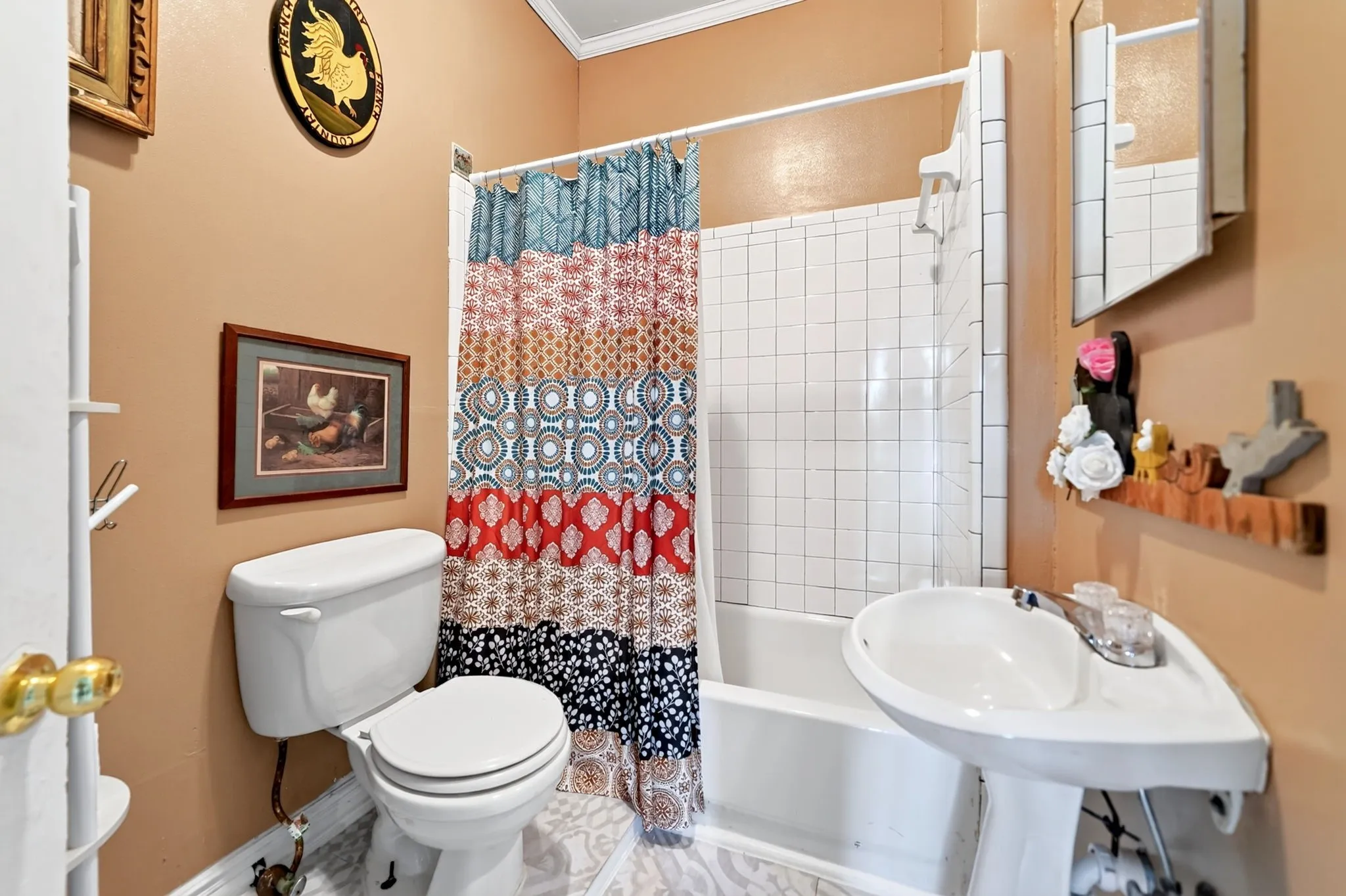 Bathroom featuring a white pedestal sink, white toilet, and a white tiled shower-over-bath