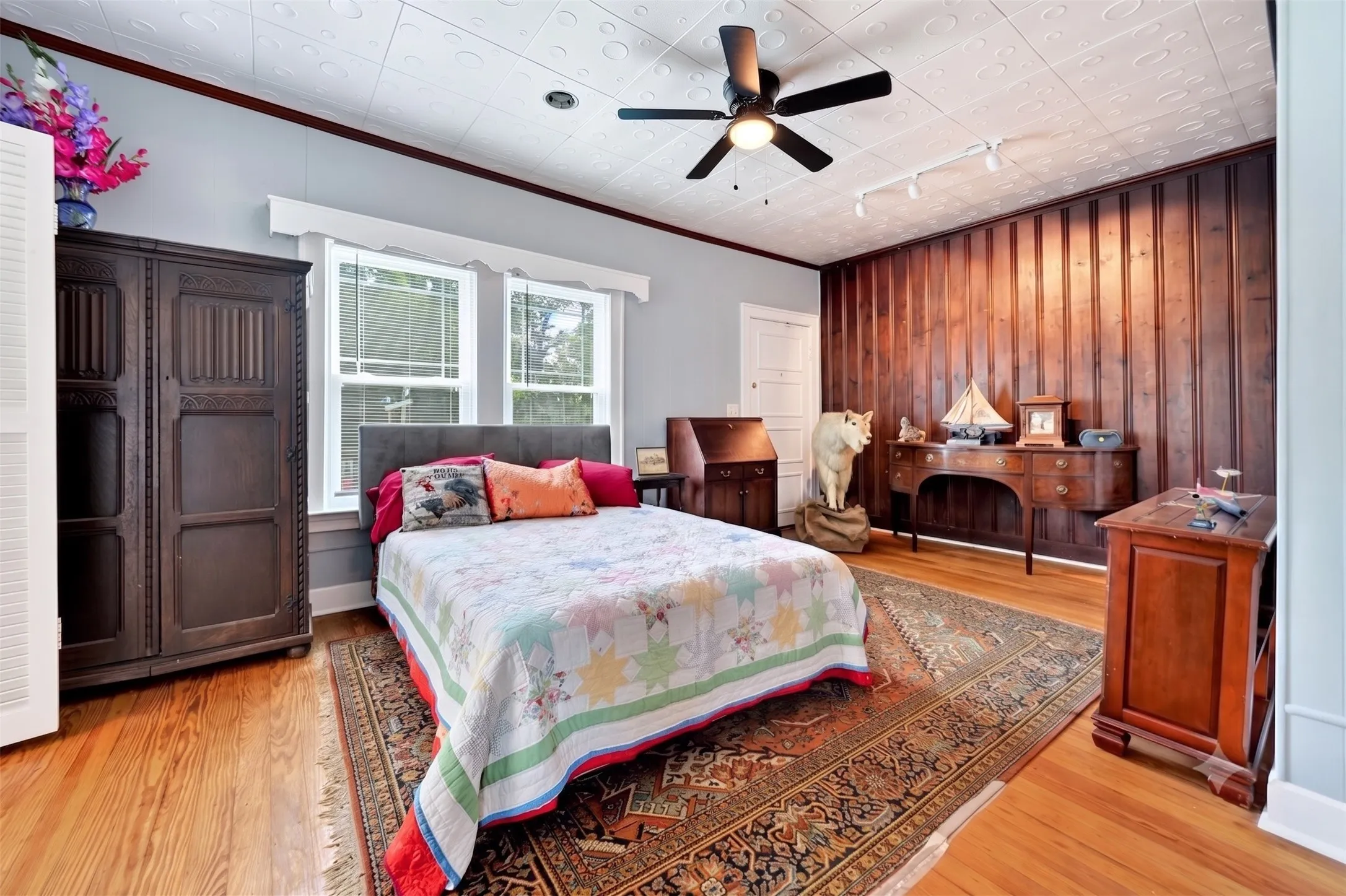 Interior room with wood-finish flooring, a textured ceiling, and a wall featuring vertical wood paneling