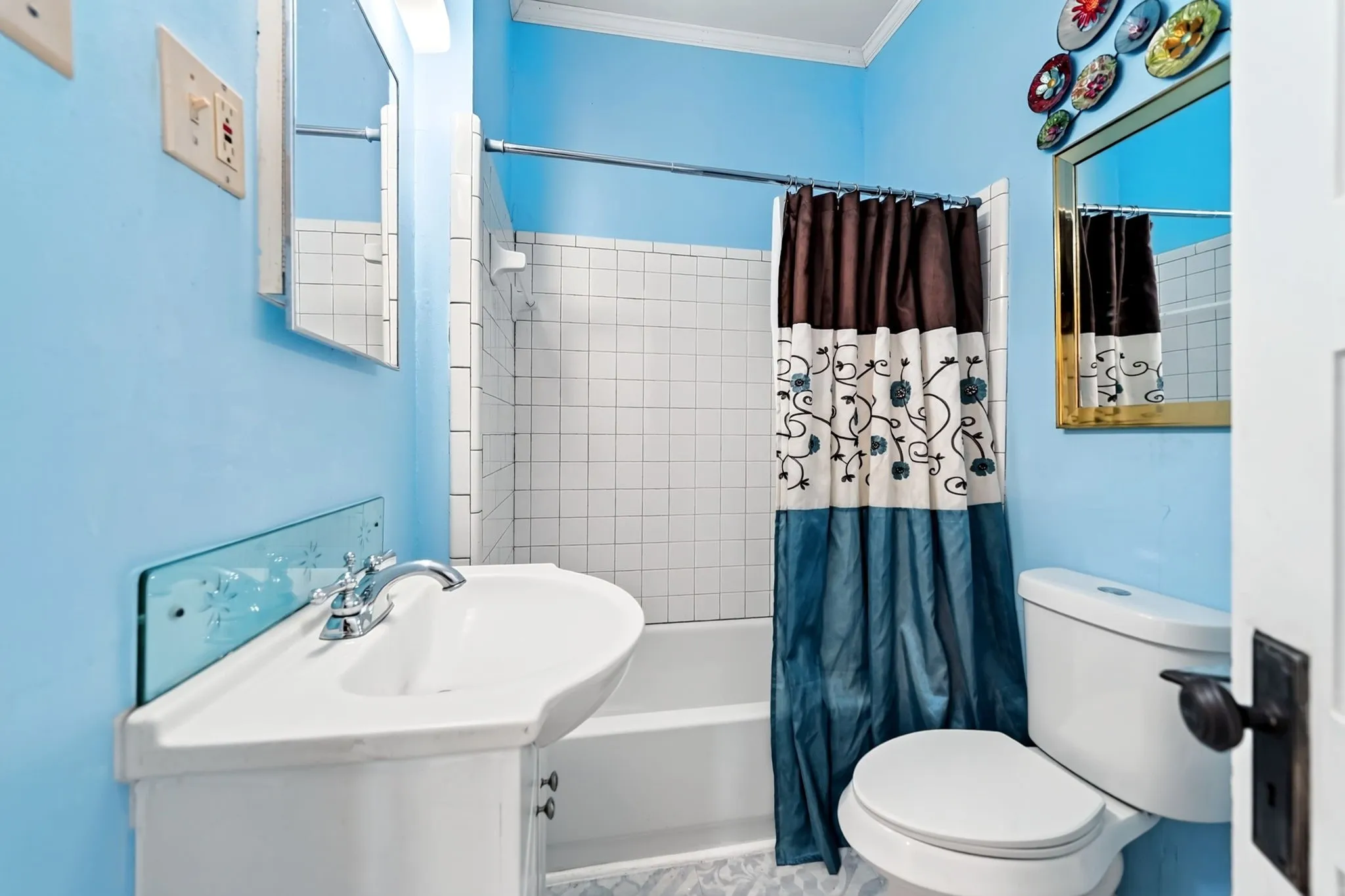 Bathroom featuring a bathtub with subway tile surround, corner vanity with integrated sink, chrome faucet, and a wall-mounted mirror
