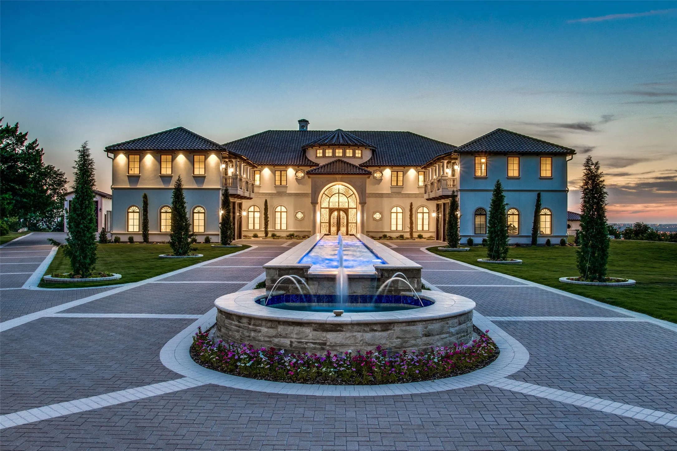 A private esplanade leads guests past the 85 foot reflecting pool with fountains to the motor court of this spectacular Mediterranean mansion.