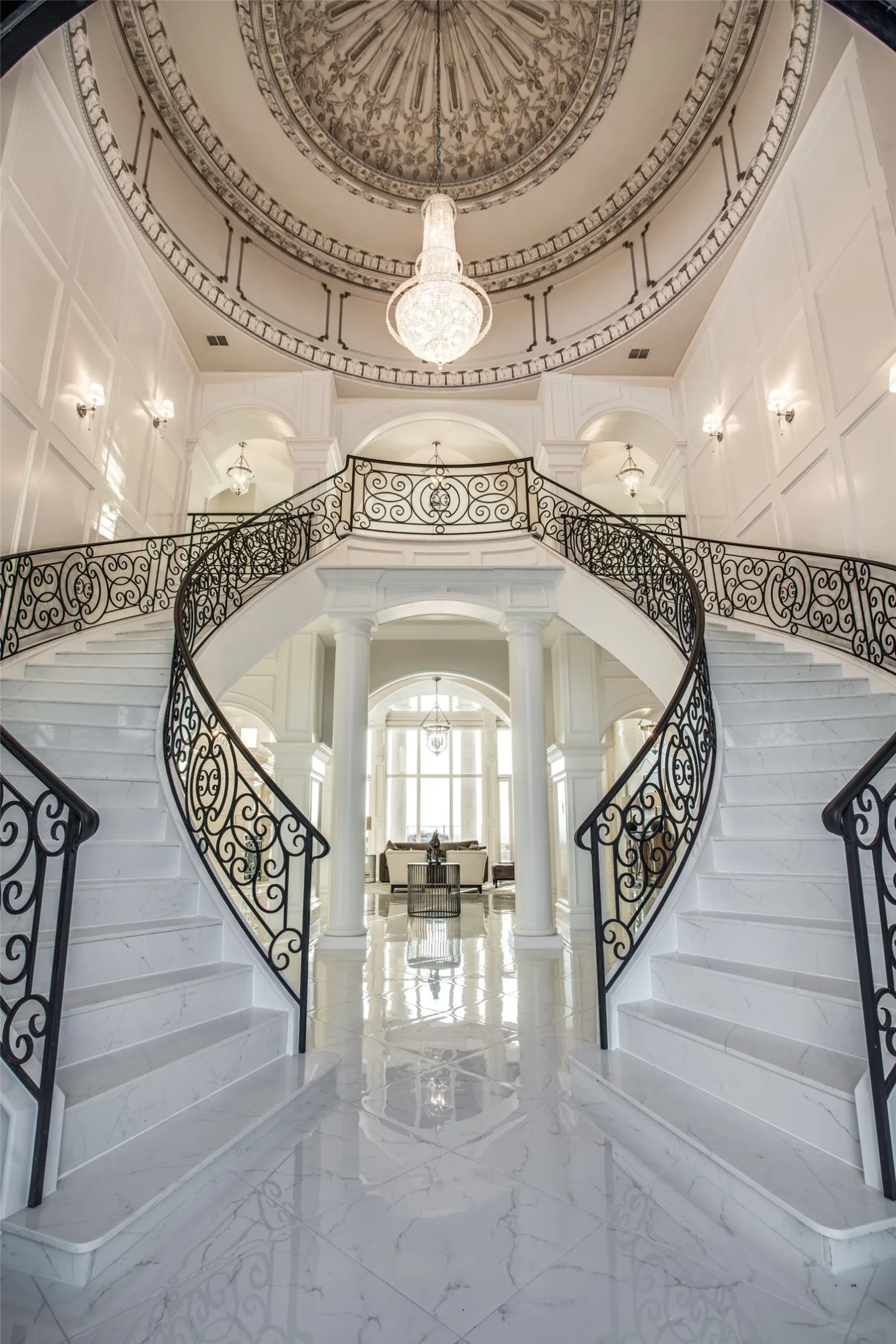 Guests are greeted with a double floating staircase, a crystal chandelier, and a hand-painted domed ceiling.