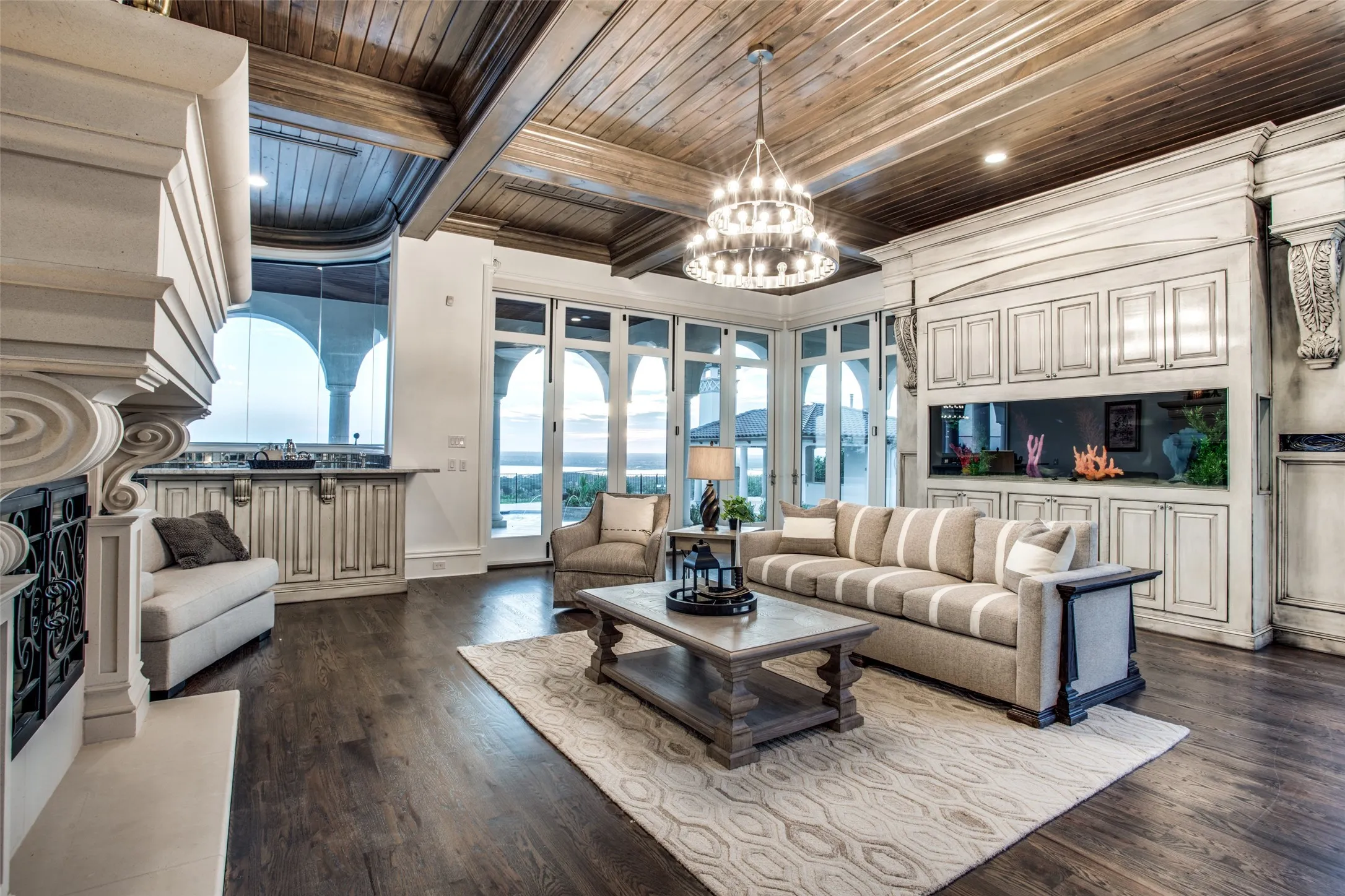 The family room provides comfortable luxury, with beautiful hardwood flooring, a salt water aquarium, a see-through fireplace, a wet bar and fold away doors to enjoy the covered patio beyond.