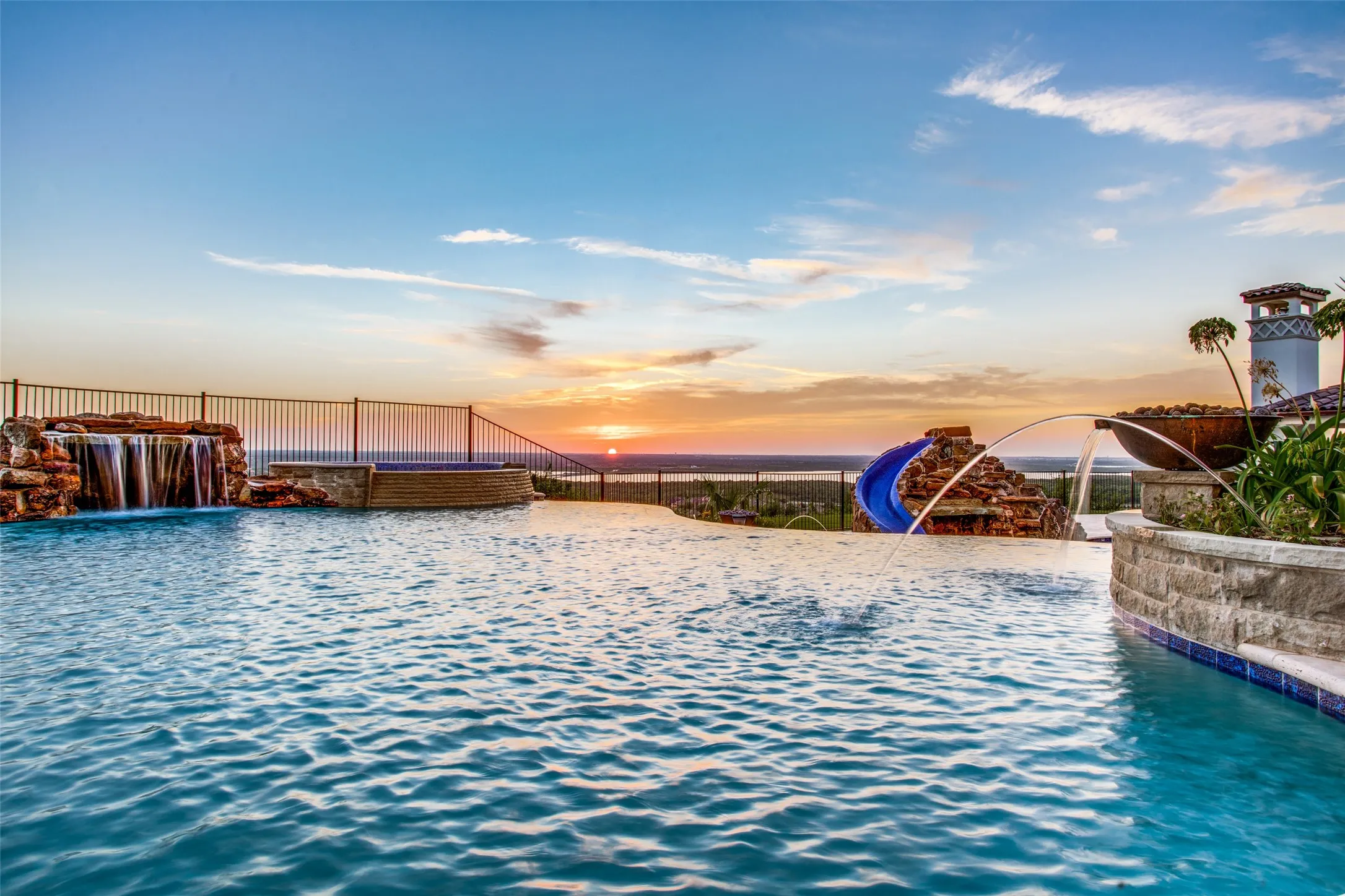 The pool has so many features to keep guests endlessly entertained--from the beautiful water features to the waterfalls and grottos, to the water slide, the 12-person spa, the fire sconces and the sunken fire pit--so many intimate areas to explore!