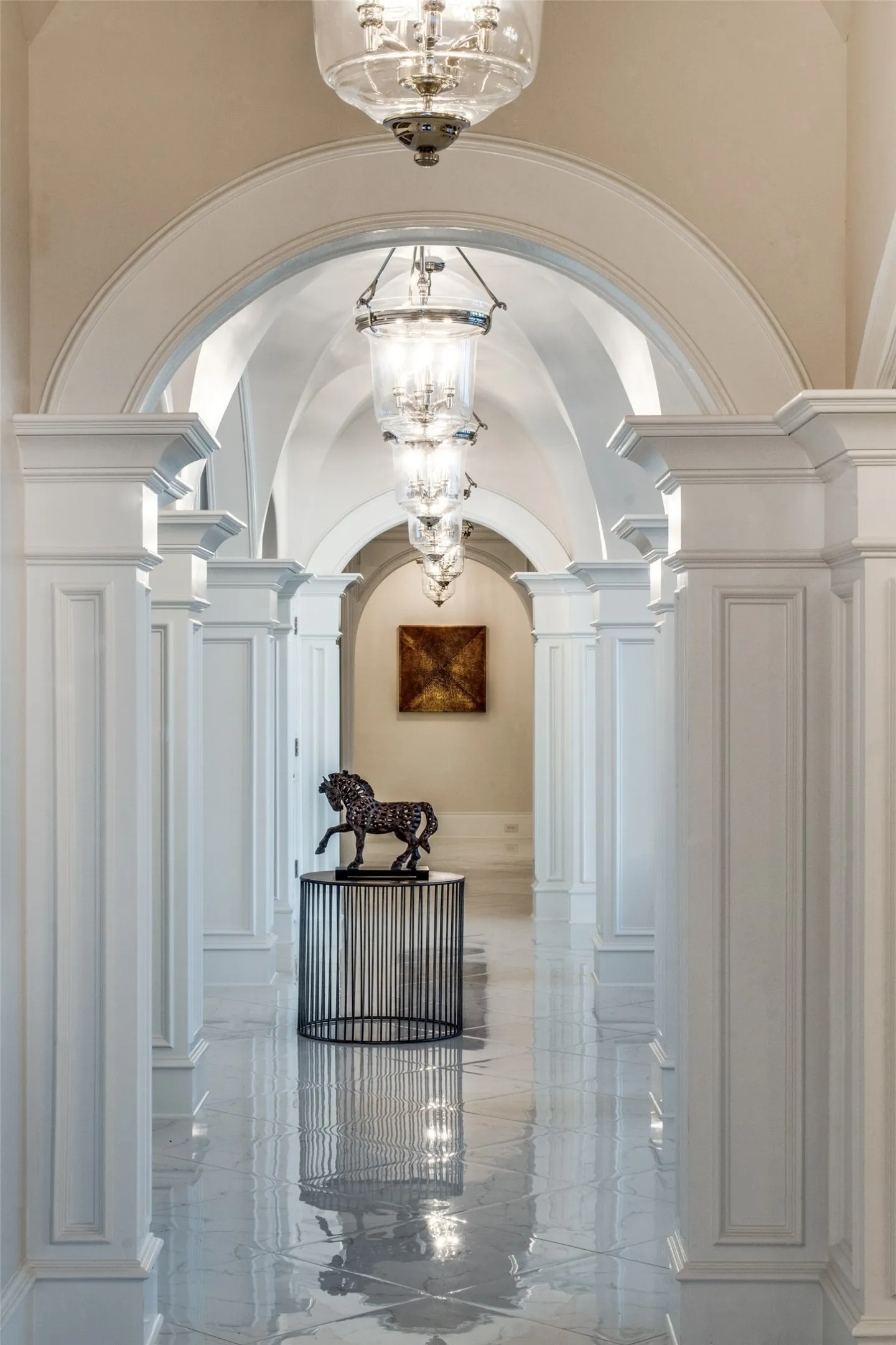 Feel the grandeur of the mansion as you walk through the elegant hallway leading from the kitchen/family room wing through the grand foyer/formal living and on to the primary suite wing.