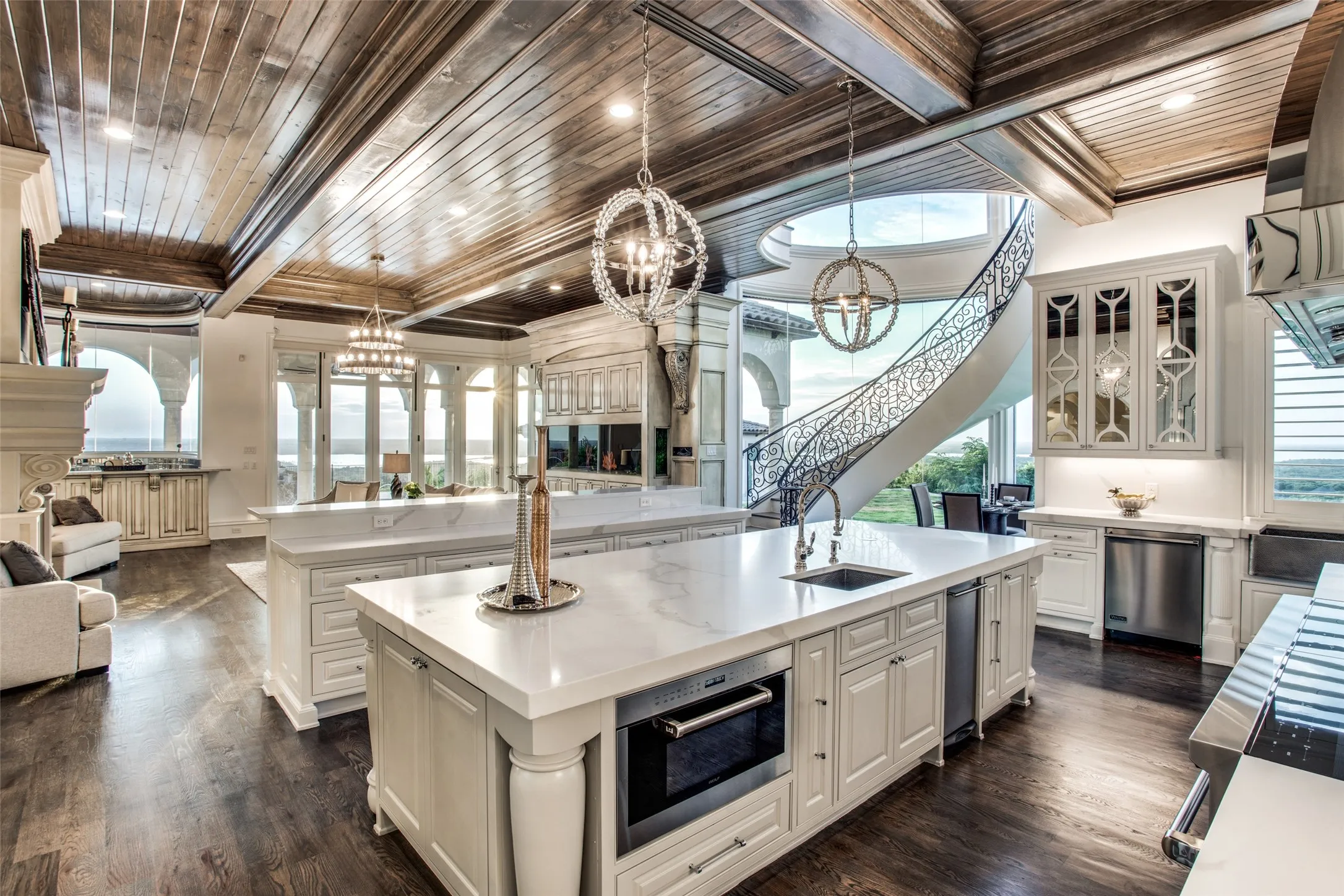 The gourmet kitchen includes Wolf and SubZero appliances, and looks into the family room featuring a see-through fireplace, salt water aquarium, wet bar and fold away doors to bring the outside in!  A floating staircase wraps around the breakfast room, leading to the game room and theater upstairs.  The kitchen and family room are bounded by walls of windows with truly breathtaking views of the surrounding areas.