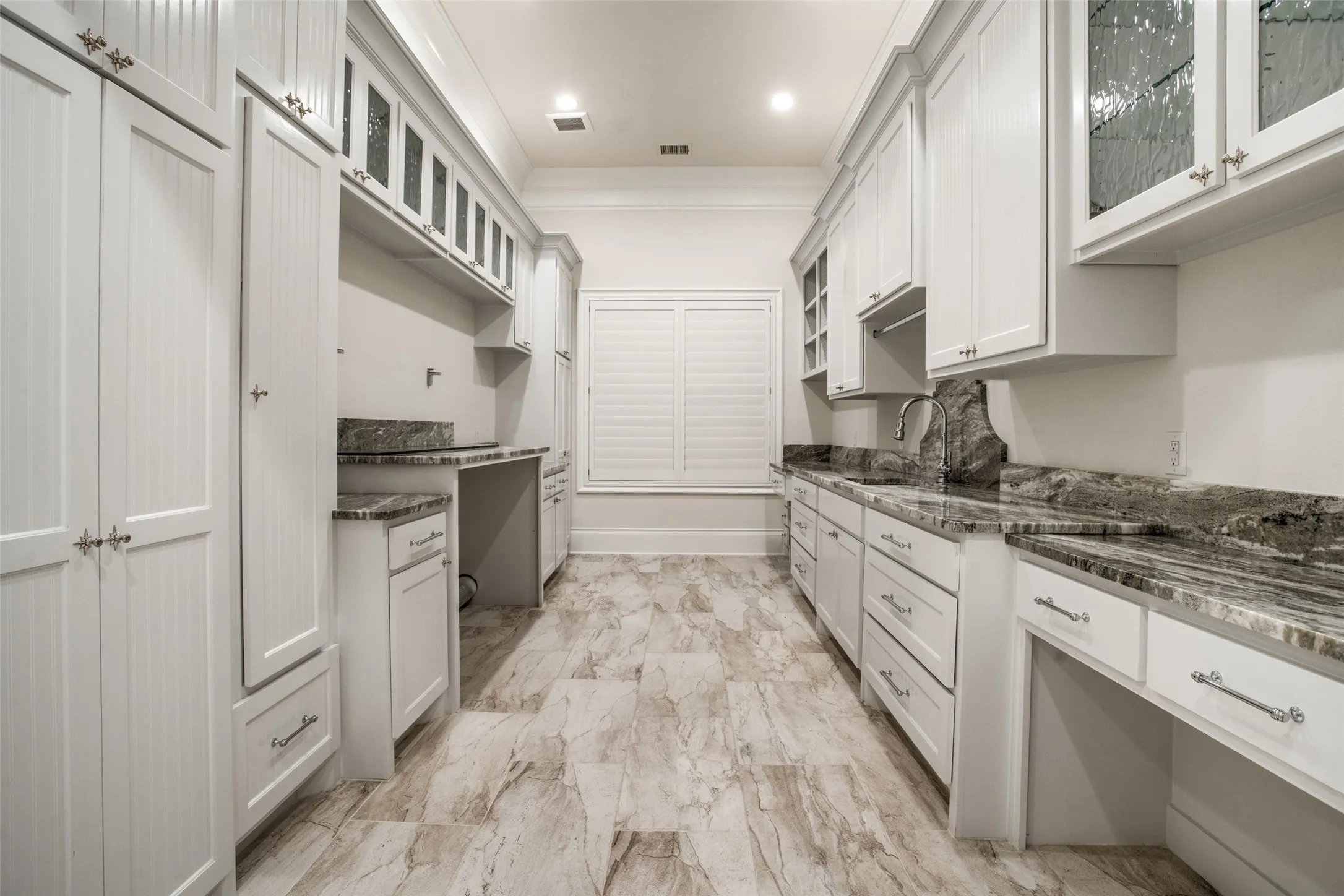 Located in the primary suite wing, the utility room features plenty of room for a washer and dryer, along with a sink and plenty of storage!