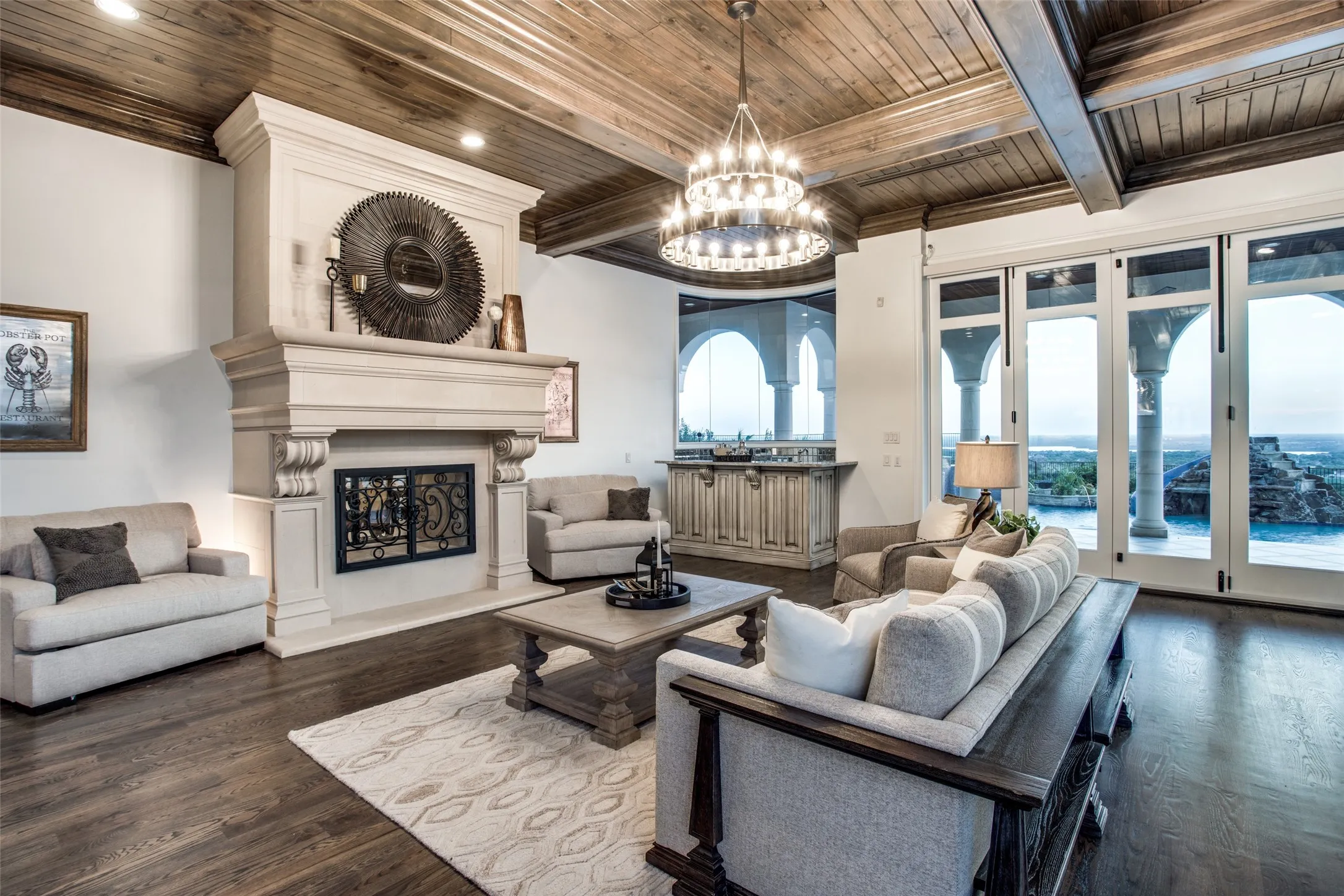 The cozy family room features a see through fireplace, wet bar and walls of windows to enjoy the amazing pool area.