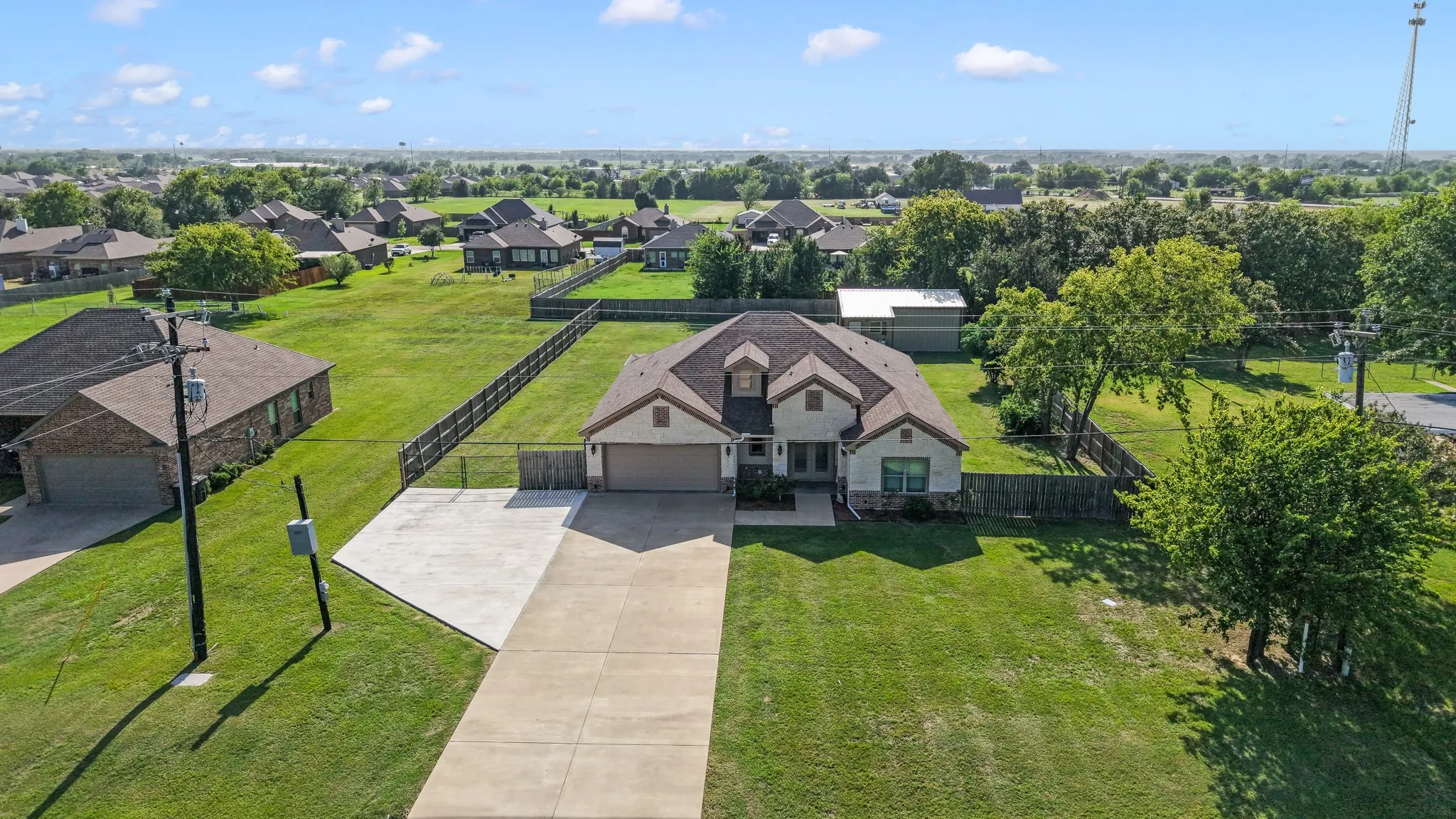 Aerial view showcasing the home, oversized backyard, and detached metal shop