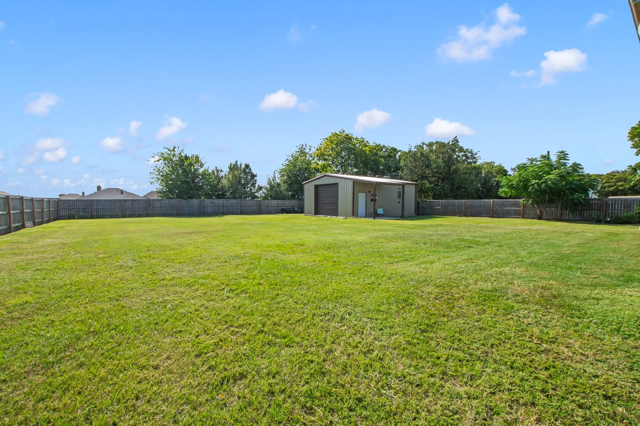 Expansive, fully fenced backyard with wooden privacy fence