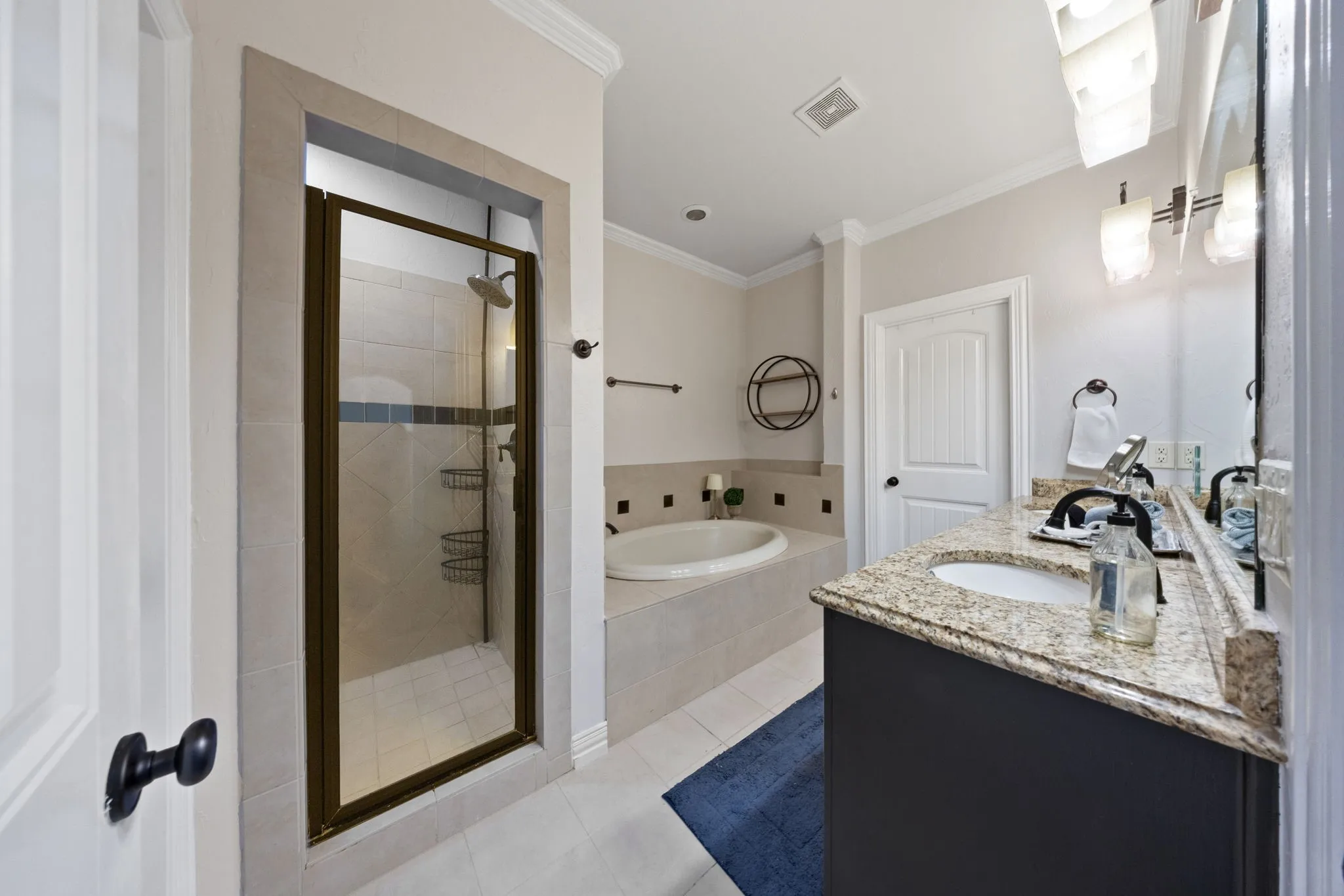 Shower enclosure with a glass door, tile surround, and an integrated showerhead