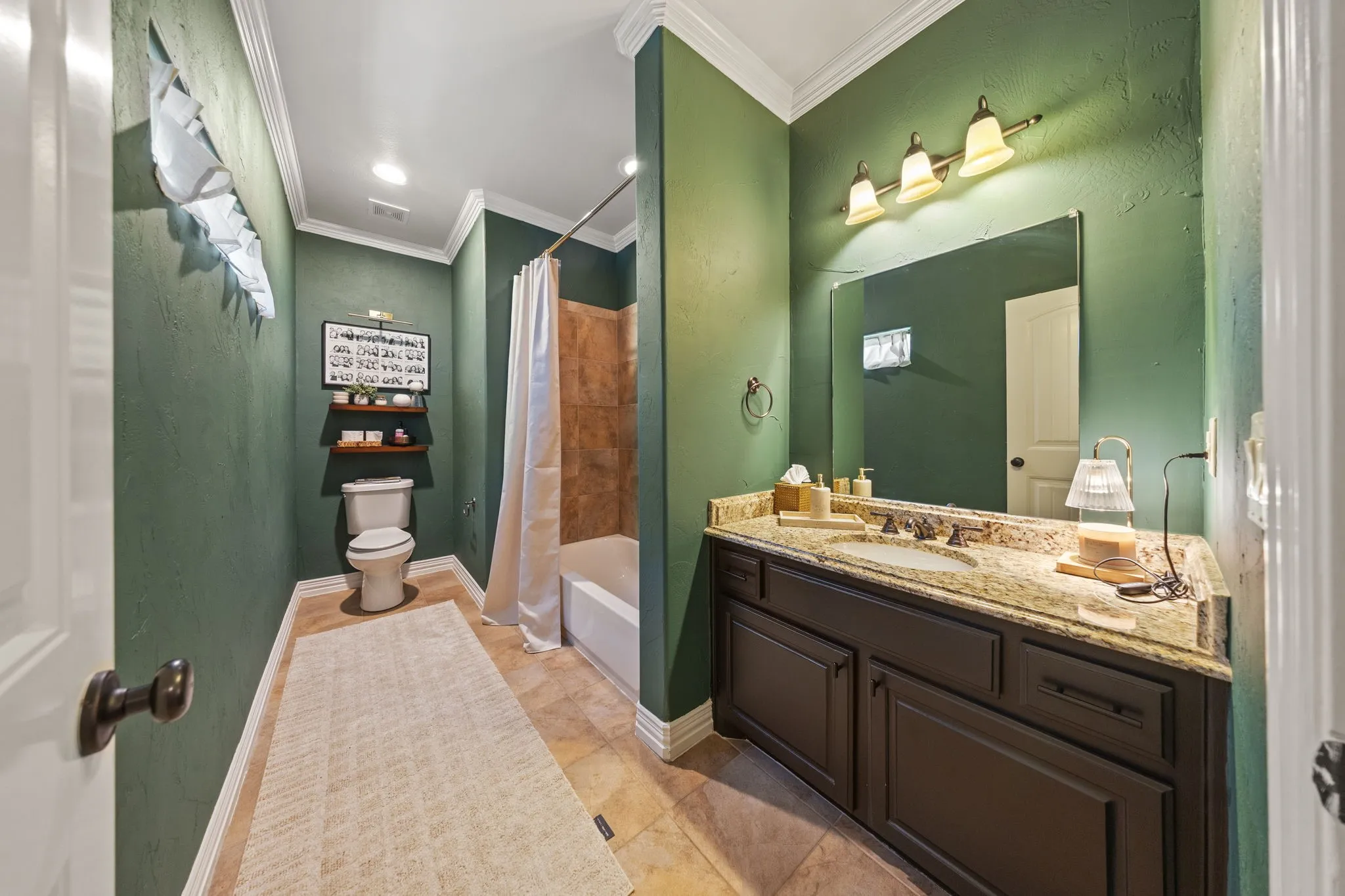 Bathroom featuring a vanity with a light-colored stone countertop, integrated sink, and dark wood-finish cabinetry