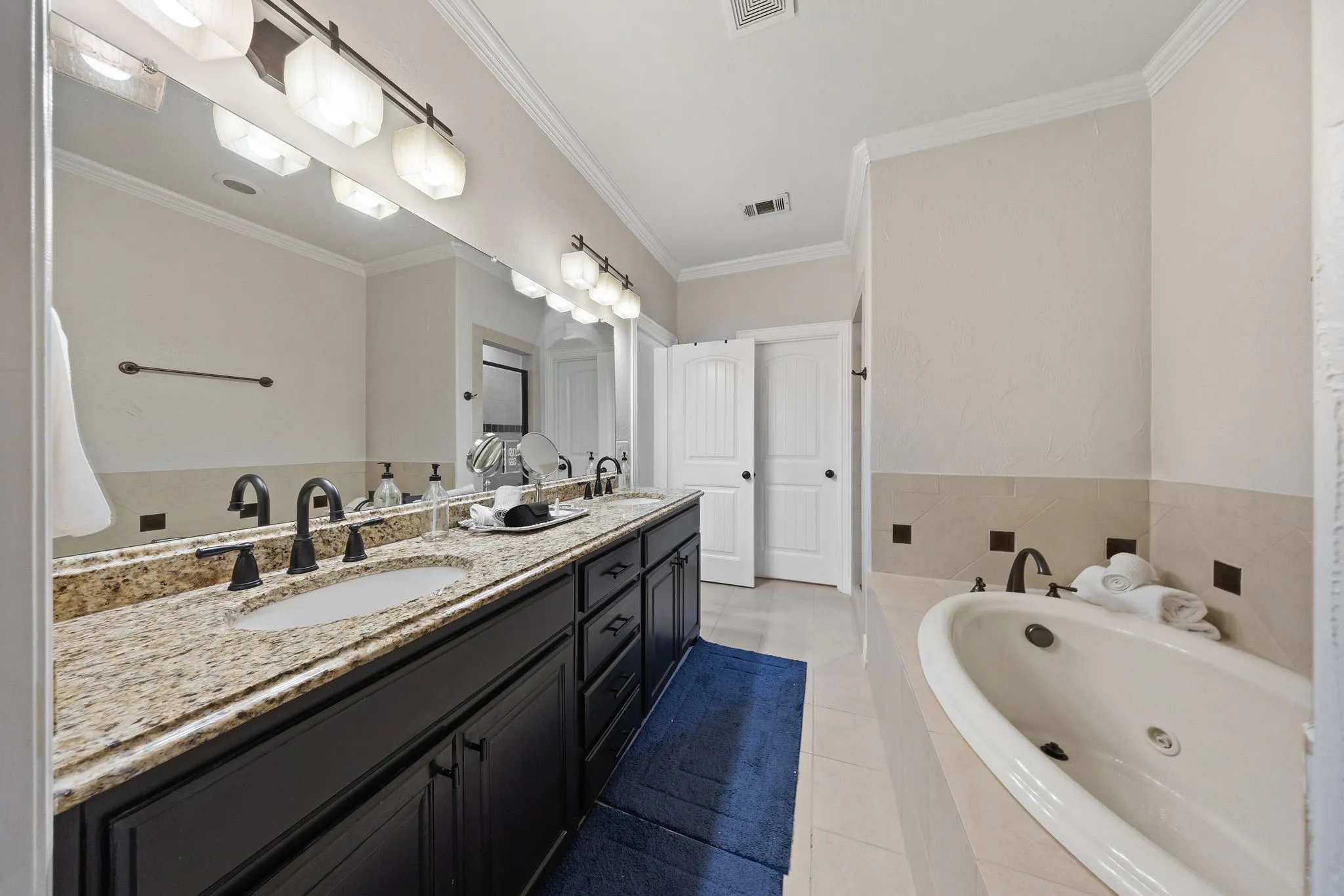 Dual vanity with undermount sinks and granite countertops, complemented by dark wood-finish cabinetry