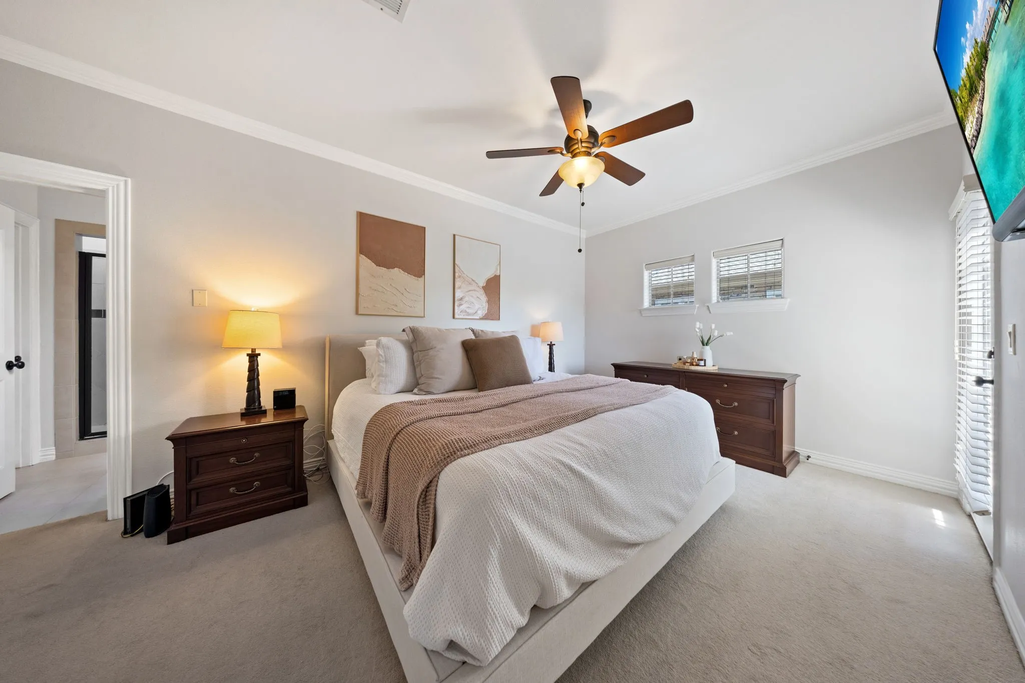 Carpeted room with crown molding, a ceiling fan with light fixture, and white window blinds