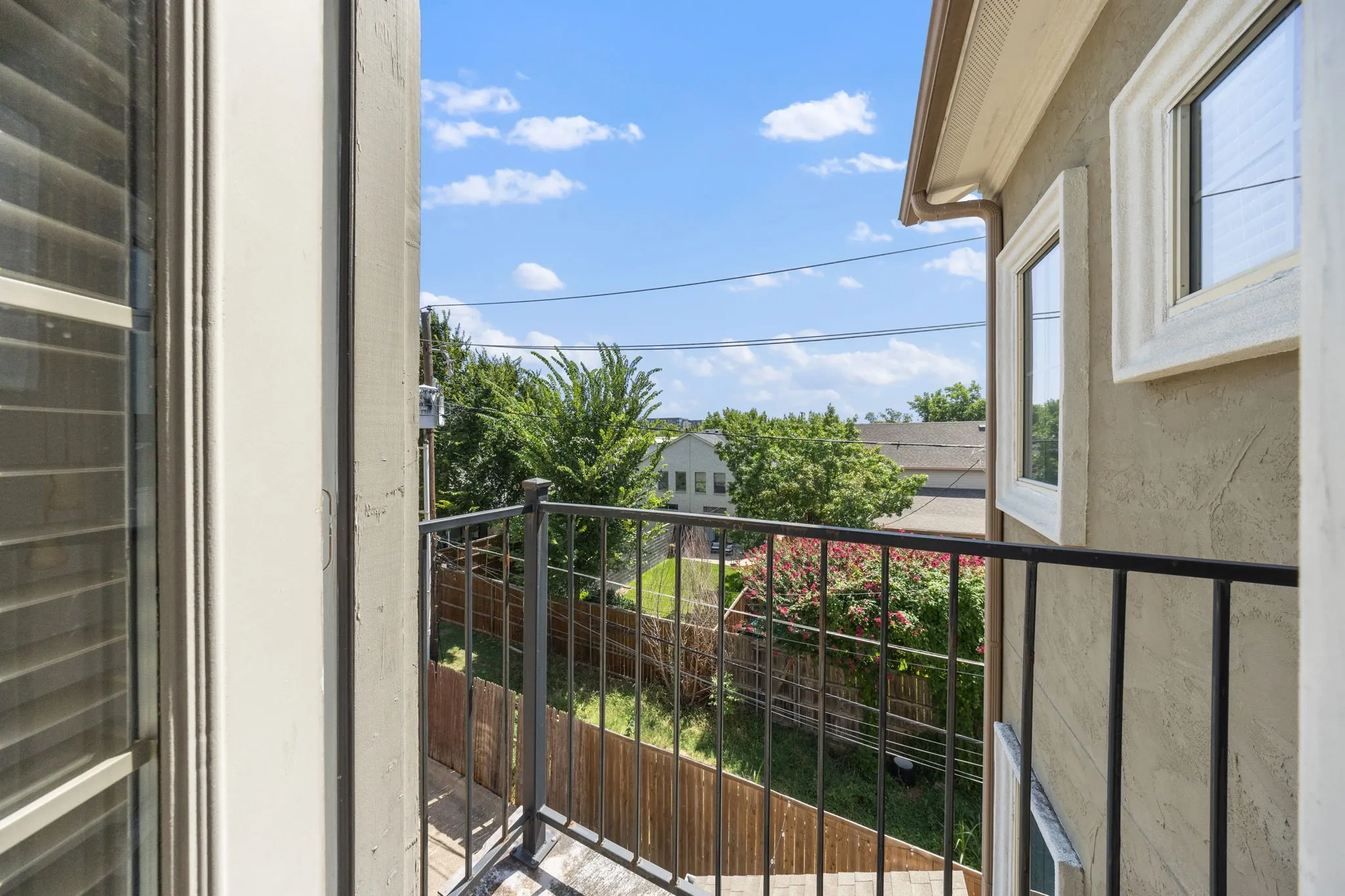 Private balcony featuring black wrought iron railing and stucco exterior