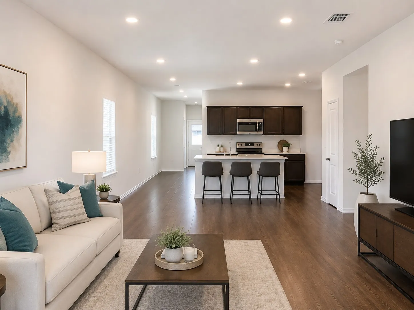 Open-concept living area featuring wood-finish flooring, recessed lighting, and white walls