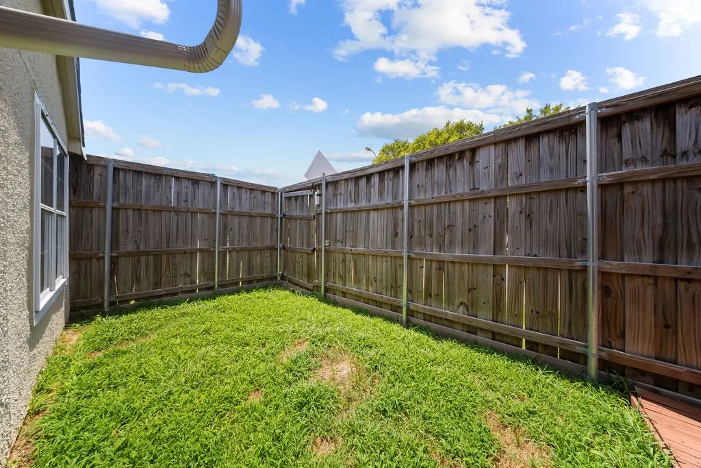 Enclosed backyard space featuring wood panel fencing with metal posts