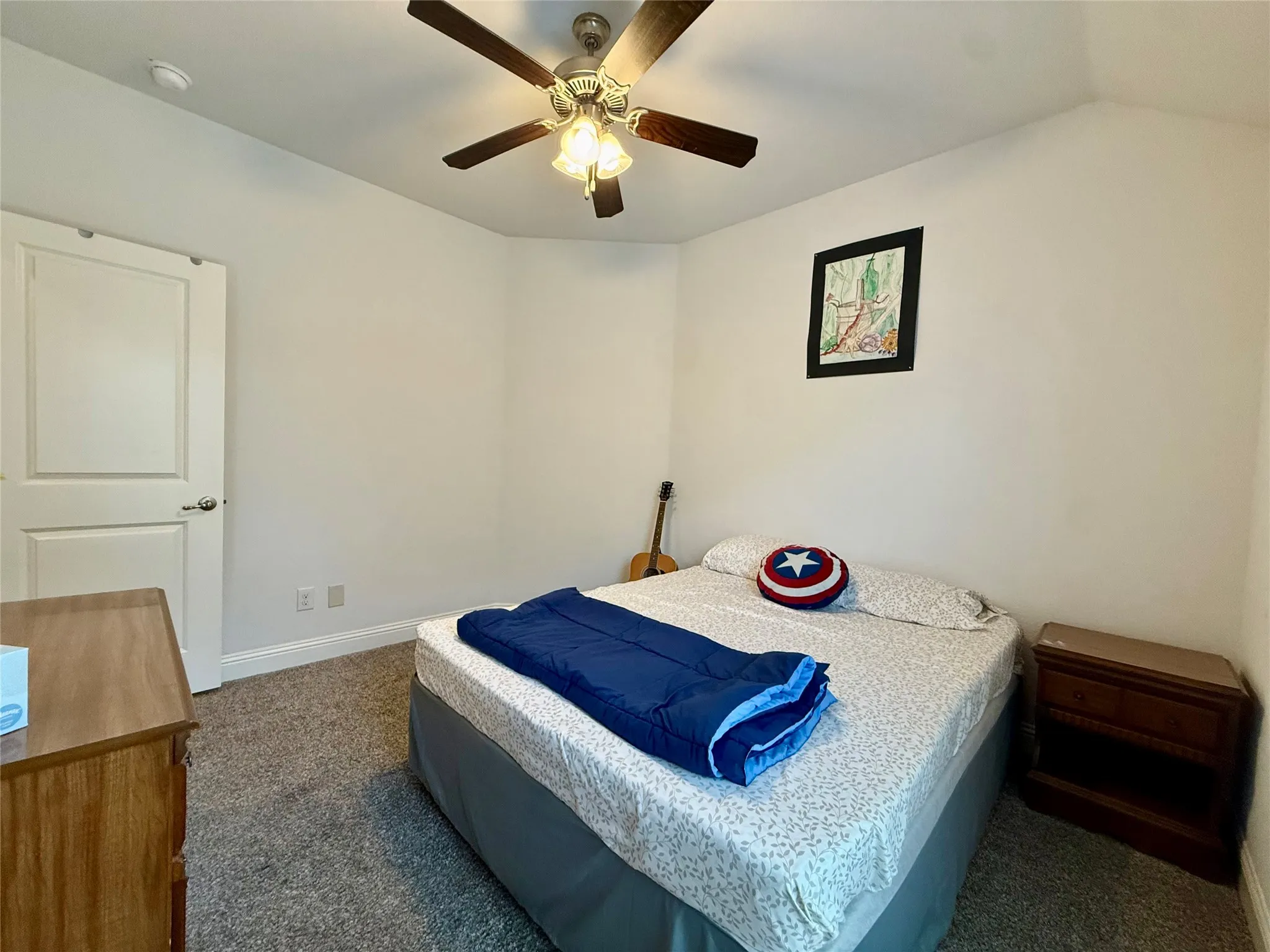 Carpeted room featuring a ceiling fan with integrated lighting, white walls, and white trim