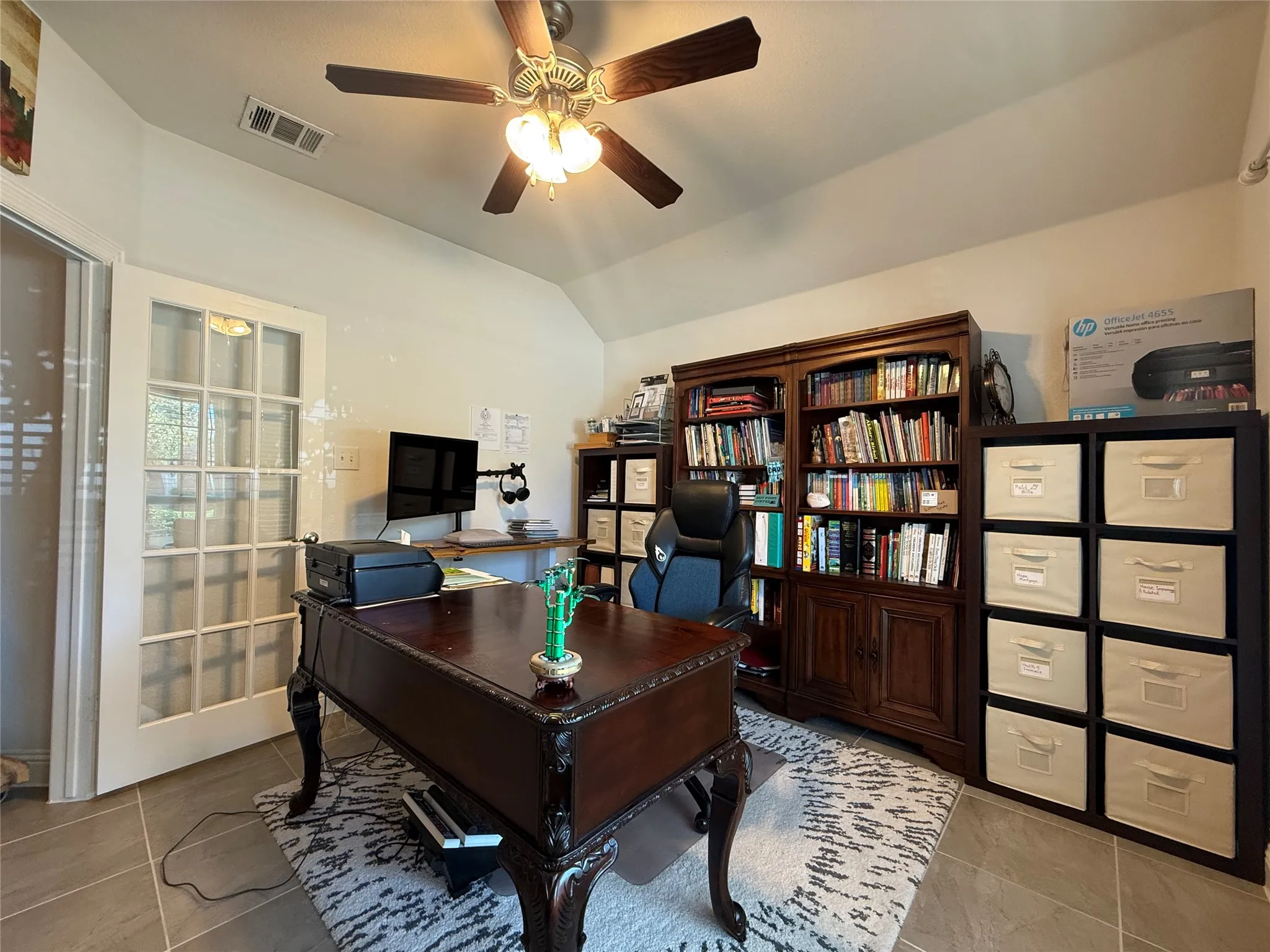 Spacious room with a ceiling fan, French doors, and tile flooring