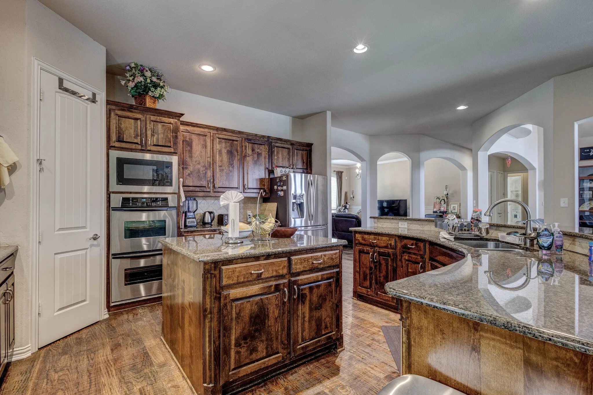 Kitchen featuring wood-finish flooring, custom wood cabinetry, and recessed lighting