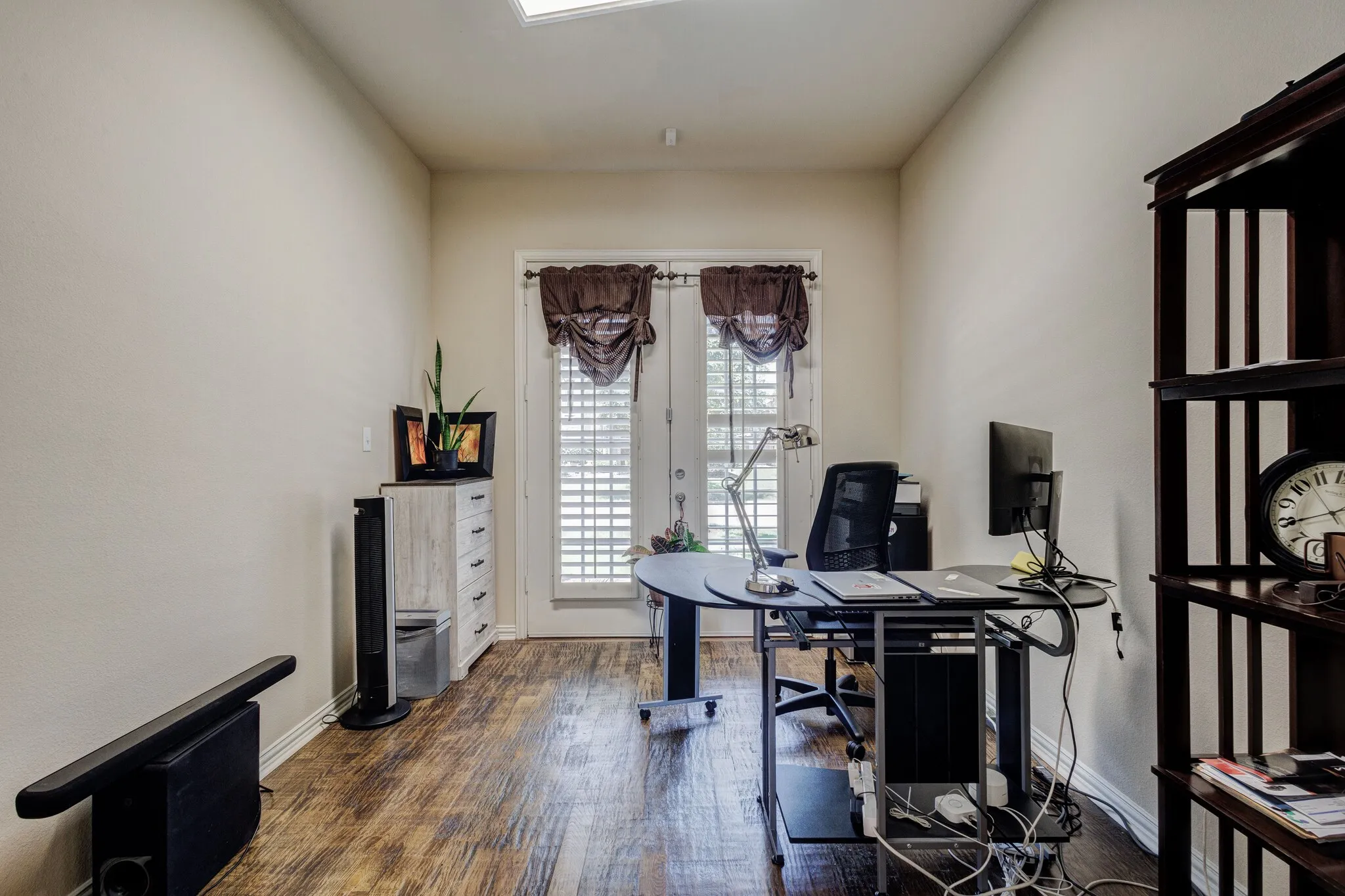 Room featuring wood-finish flooring, light-toned walls, and a white ceiling with recessed lighting