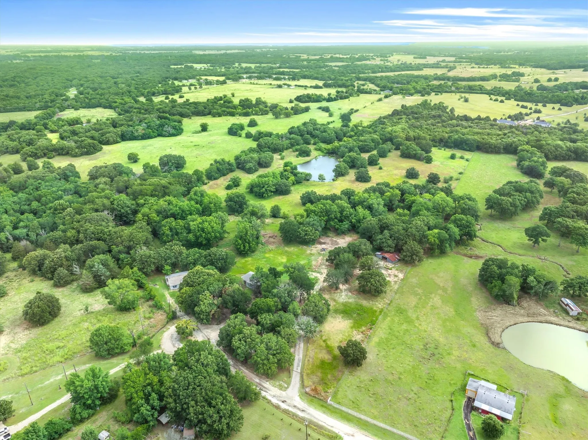 Expansive acreage showcasing verdant pastures and mature tree lines