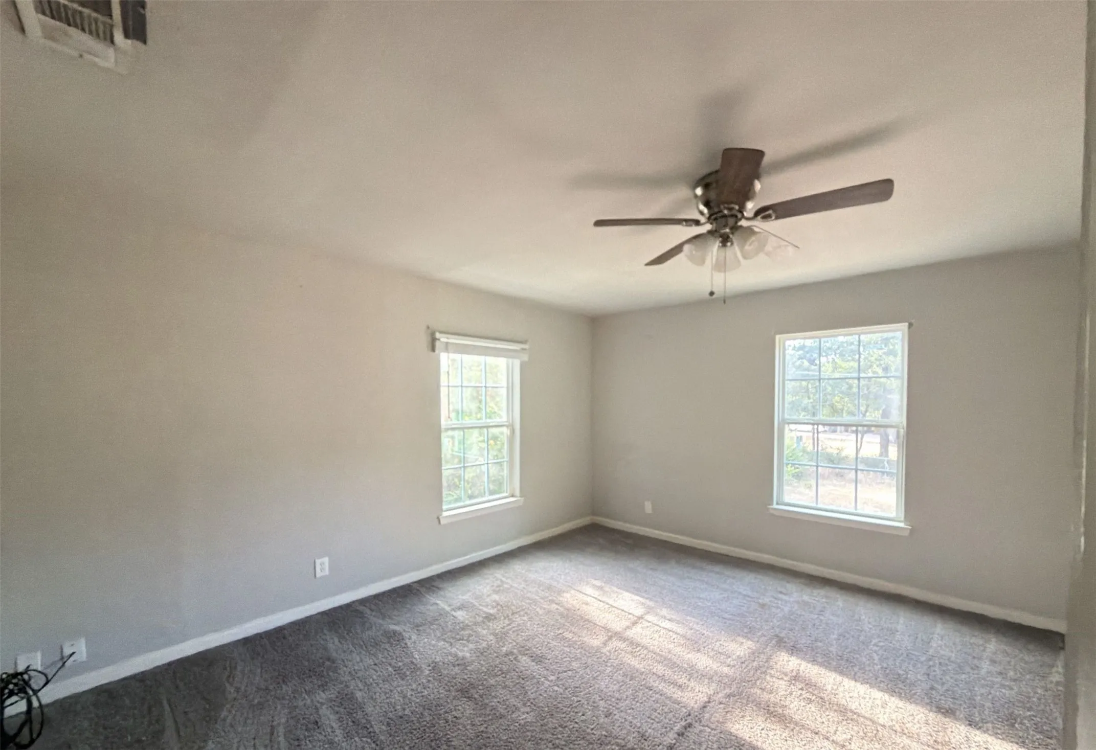 Large primary bedroom with ceiling fan, plenty of natural light and ensuite bath.