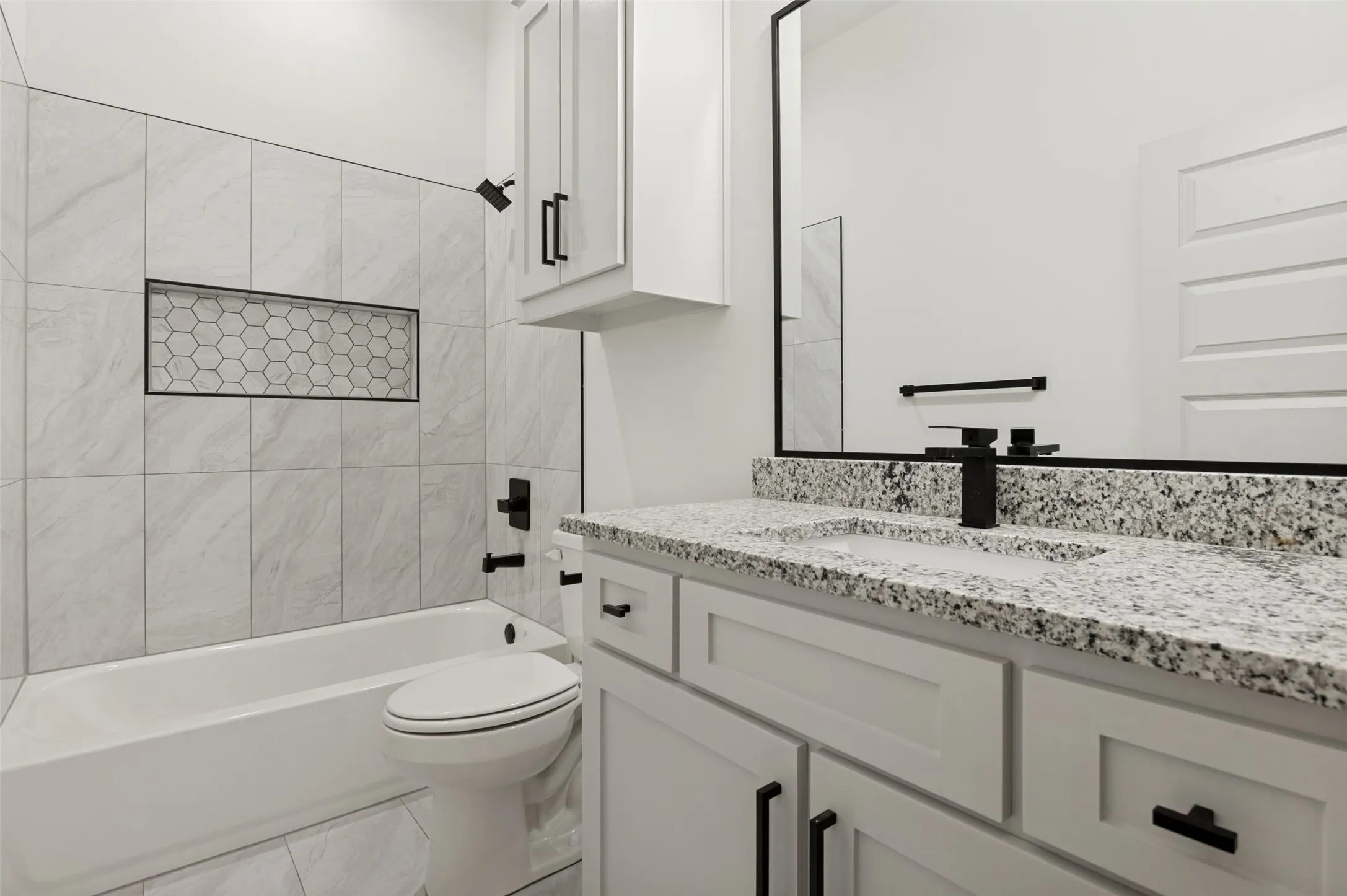 Bathtub and shower combination with a recessed niche featuring hexagonal tile
