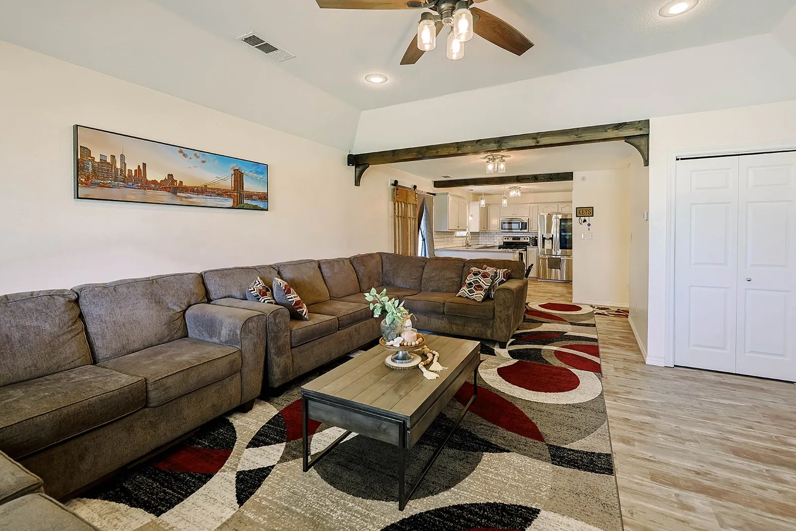 Spacious living area featuring vaulted ceilings, recessed lighting, and wood-finish flooring