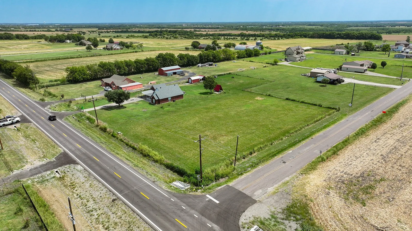 Expansive rural property featuring multiple outbuildings and structures set on substantial acreage with manicured pasture land