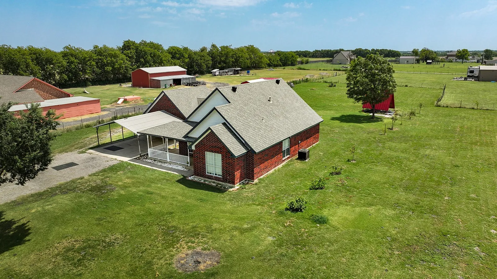 Brick exterior residence with a covered porch and carport