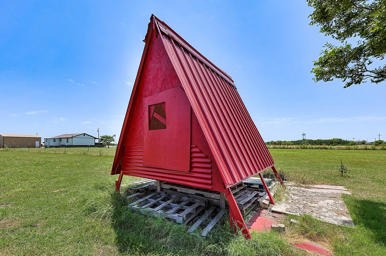 Bee House Red A-frame structure featuring a metal roof and a small window aperture