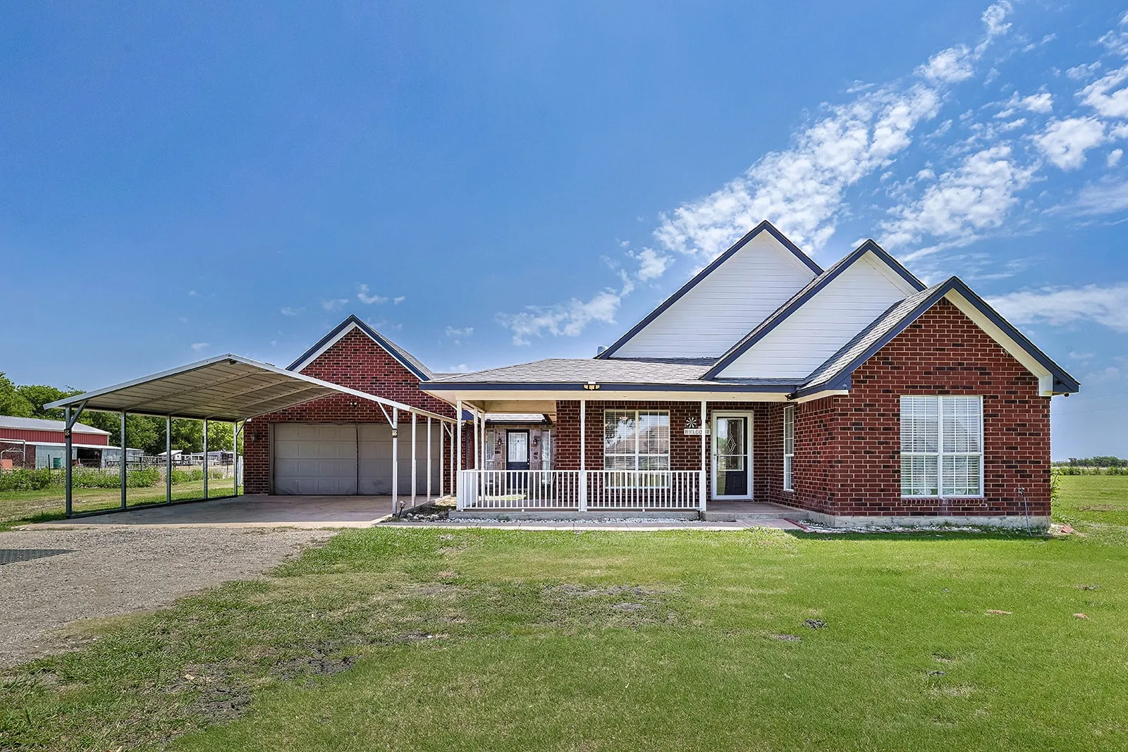 Brick exterior residence featuring white siding gables and a covered front porch with white railing