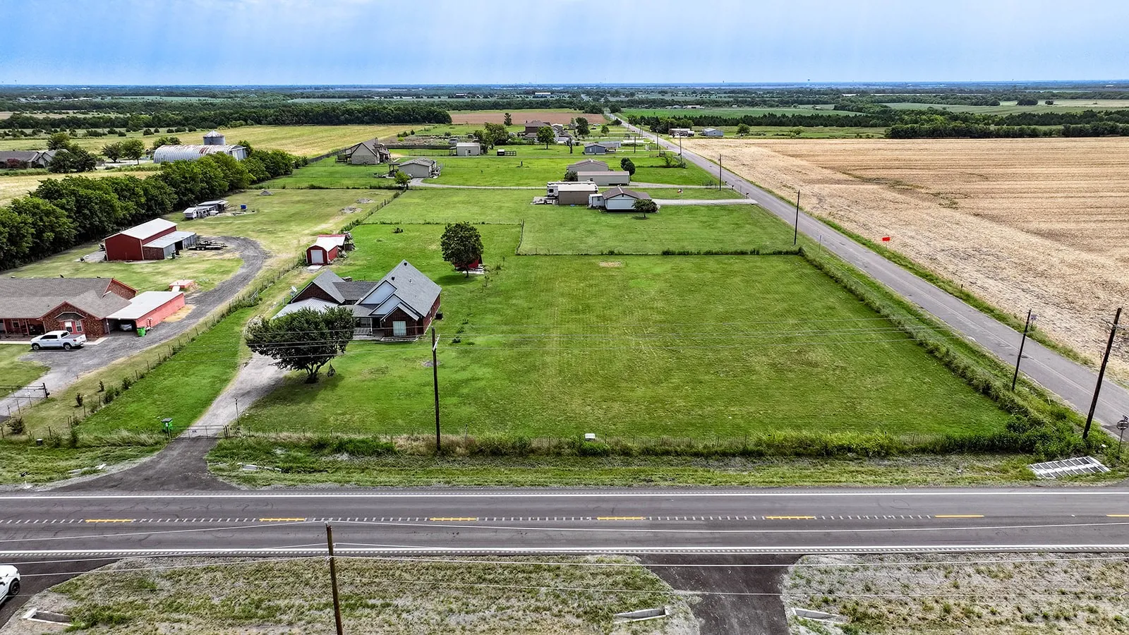 Expansive green land parcel with direct paved road frontage