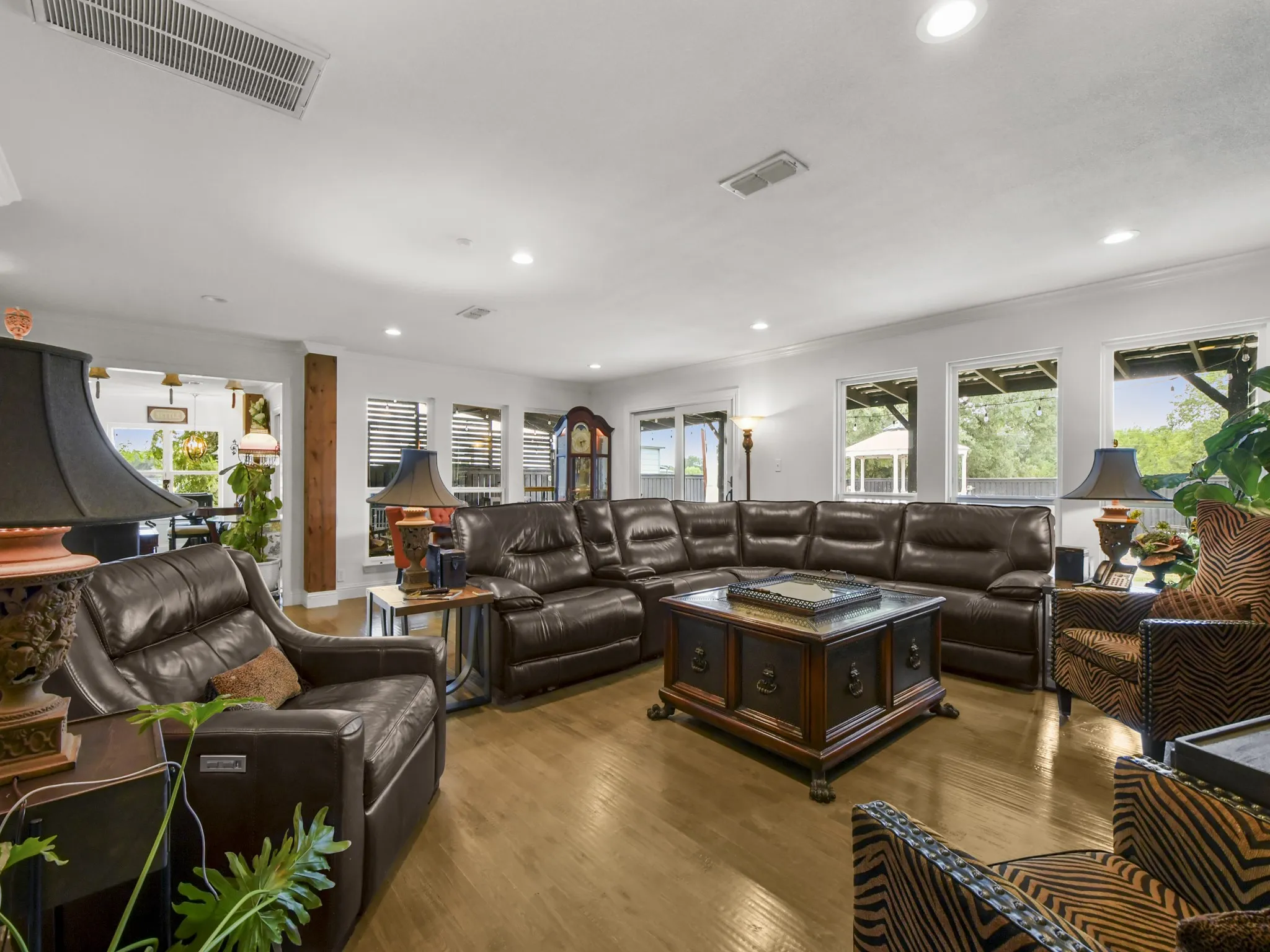 Spacious living area featuring wood-finish flooring, recessed lighting, and multiple windows