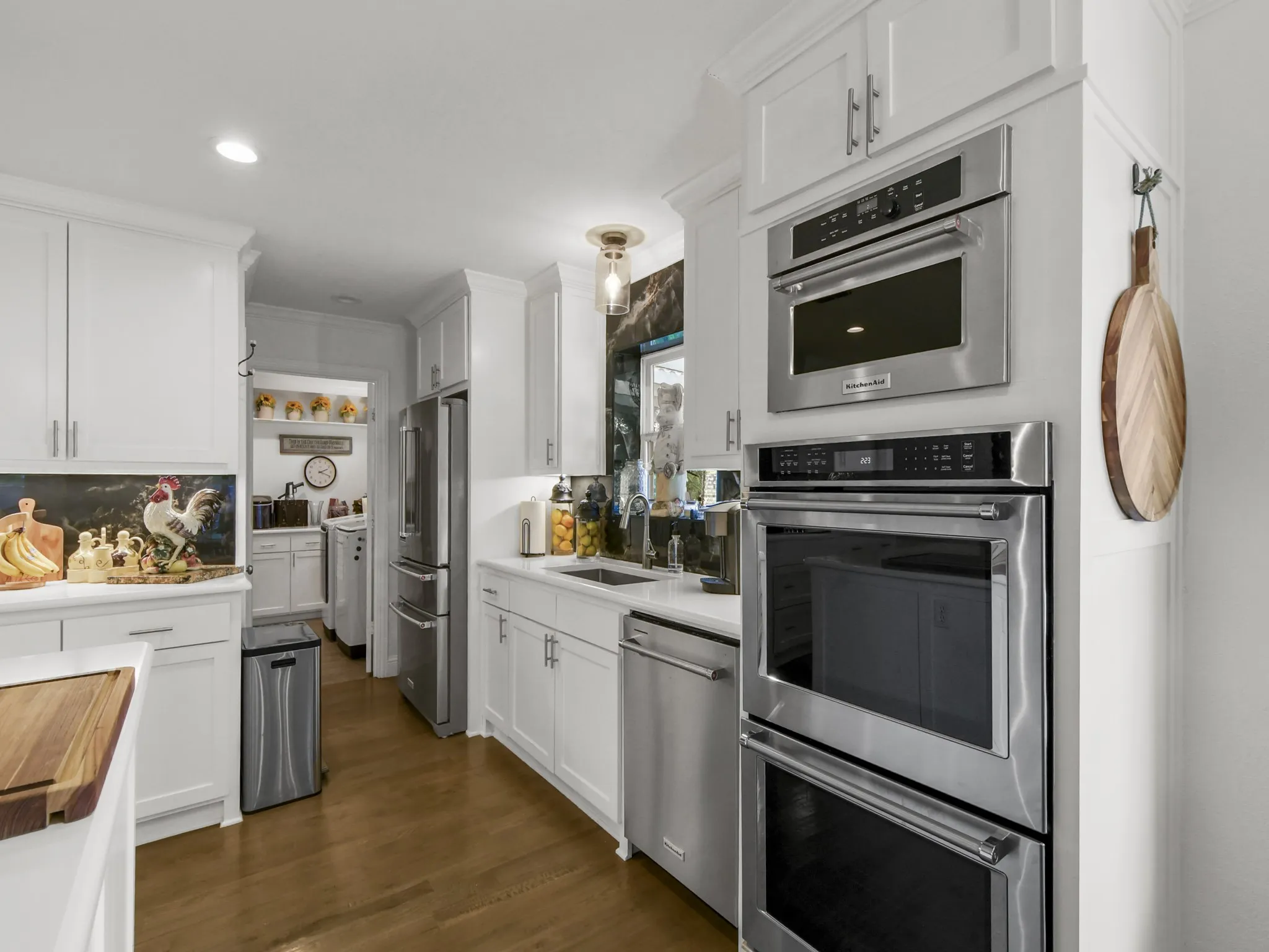 Modern kitchen featuring white cabinetry, stainless steel appliances, wood-finish flooring, recessed lighting, and a double wall oven