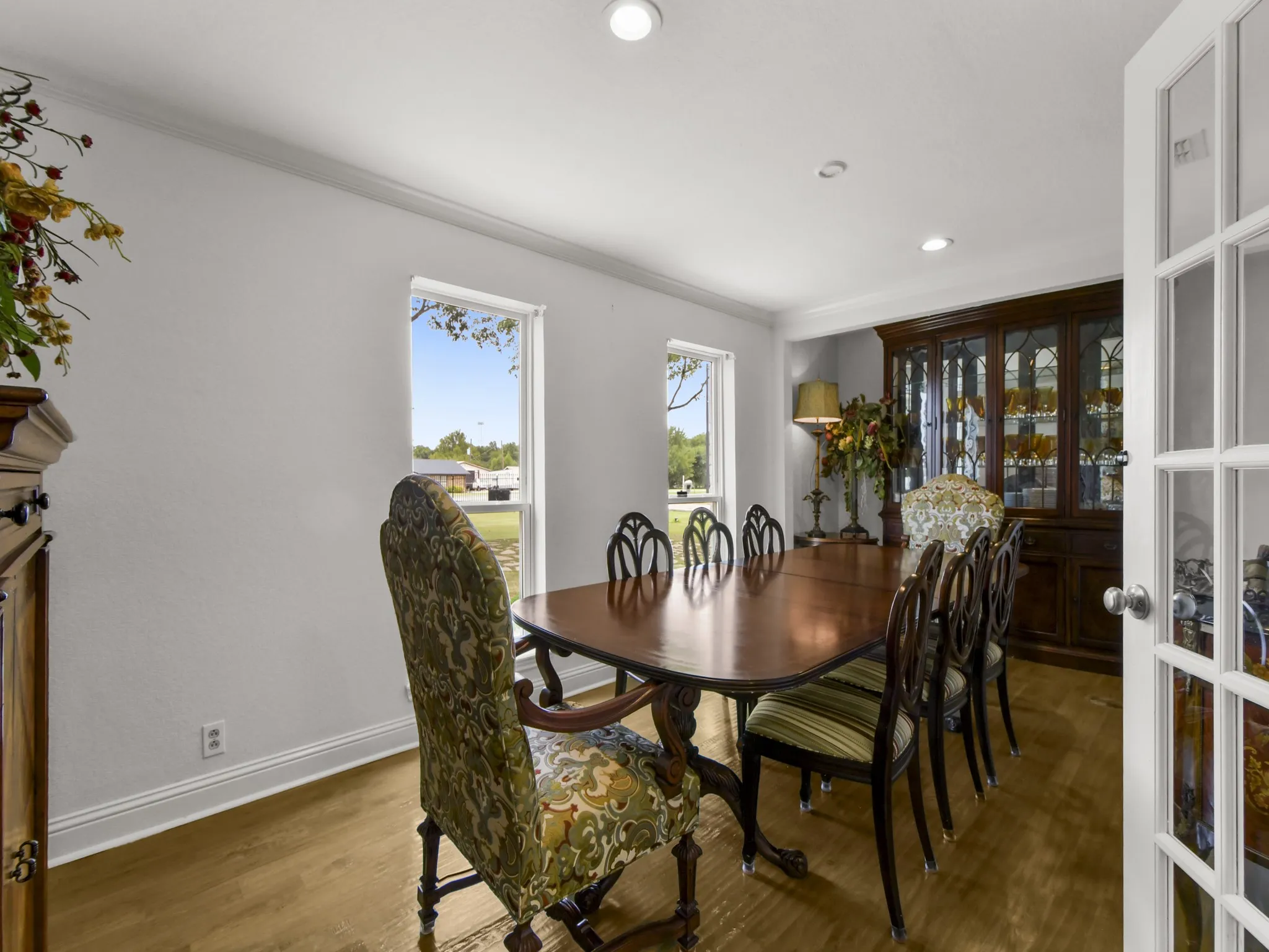 Dining area featuring wood-finish flooring, two large windows, crown molding, and recessed lighting