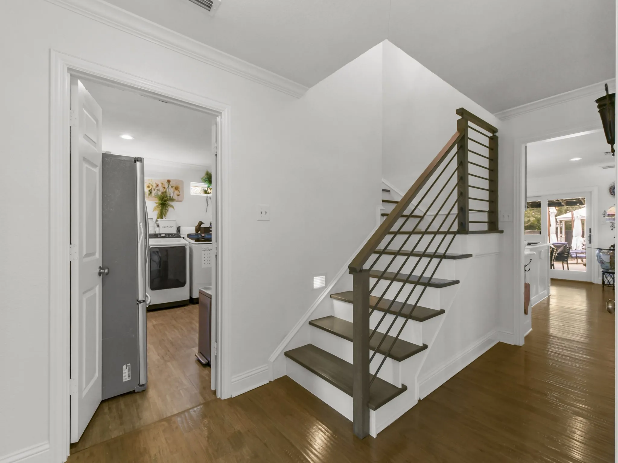 Modern staircase featuring dark wood-finish treads, a contrasting handrail, and sleek metal balusters