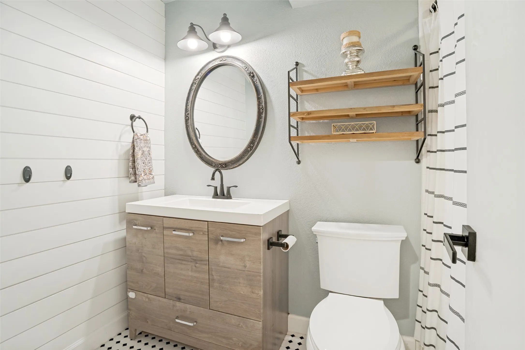Bathroom vanity with a white countertop and wood-finish cabinetry