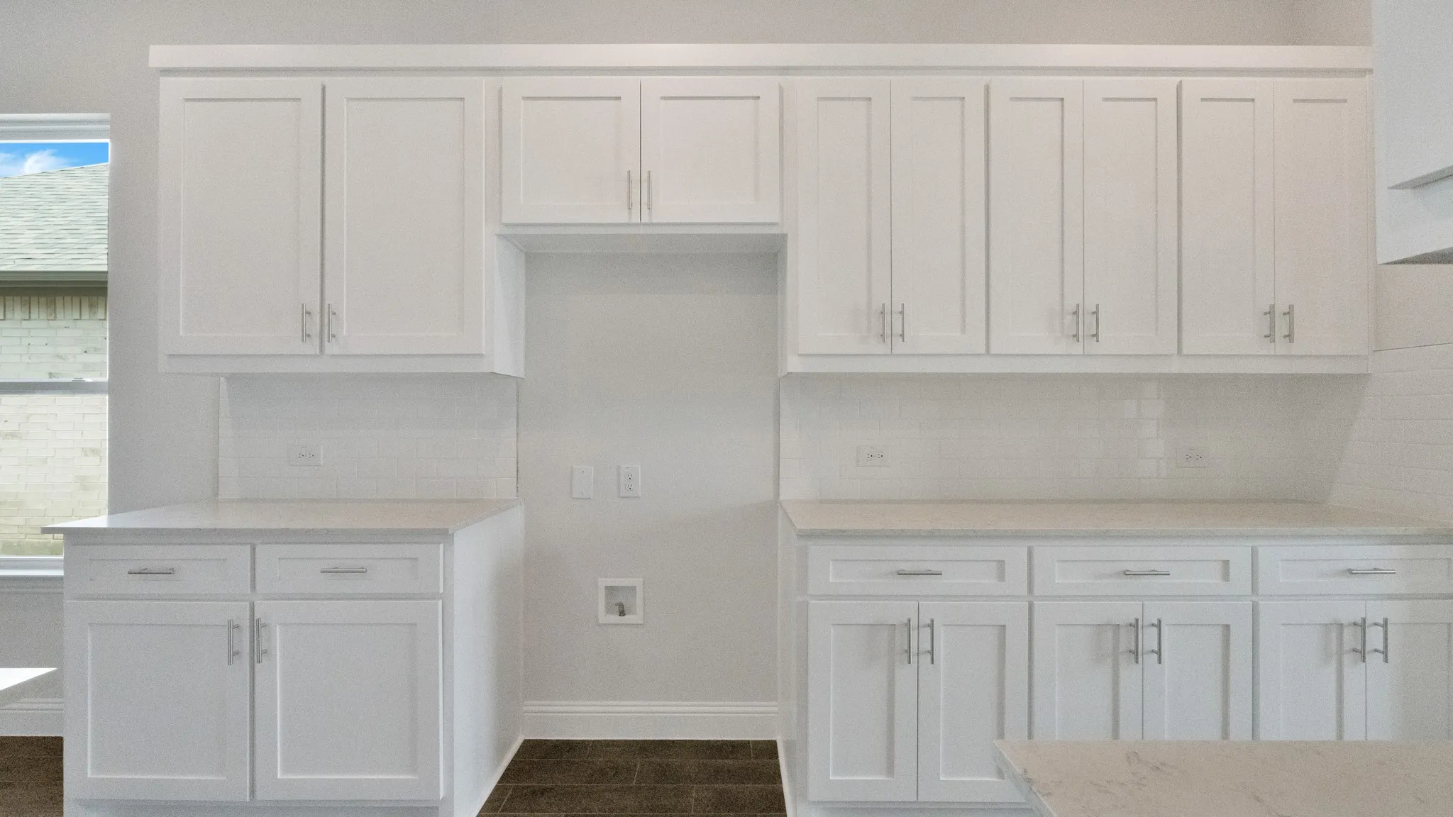 Kitchen featuring white cabinetry, tasteful backsplash, and light stone countertops