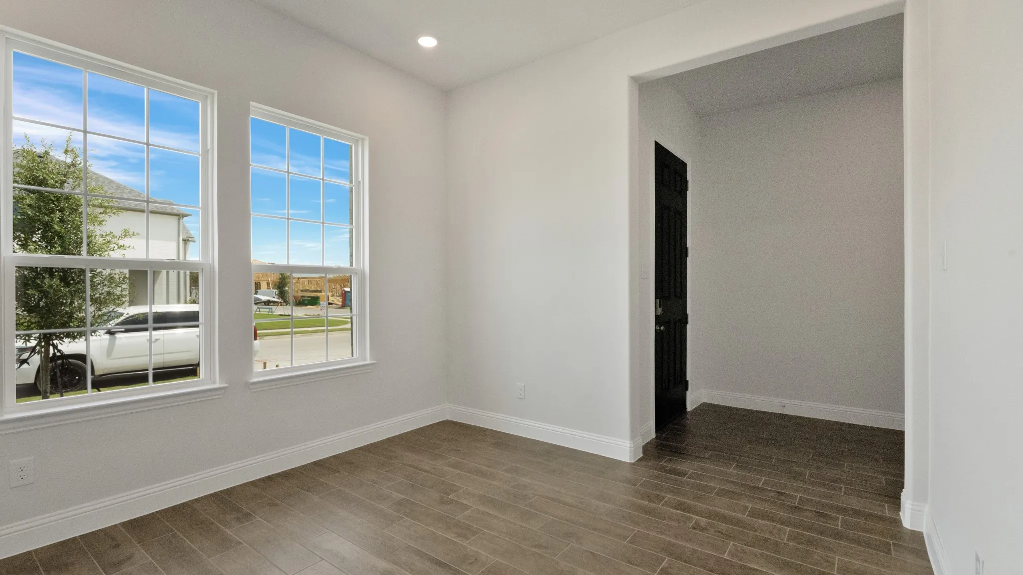 Empty room with dark wood-style floors and recessed lighting