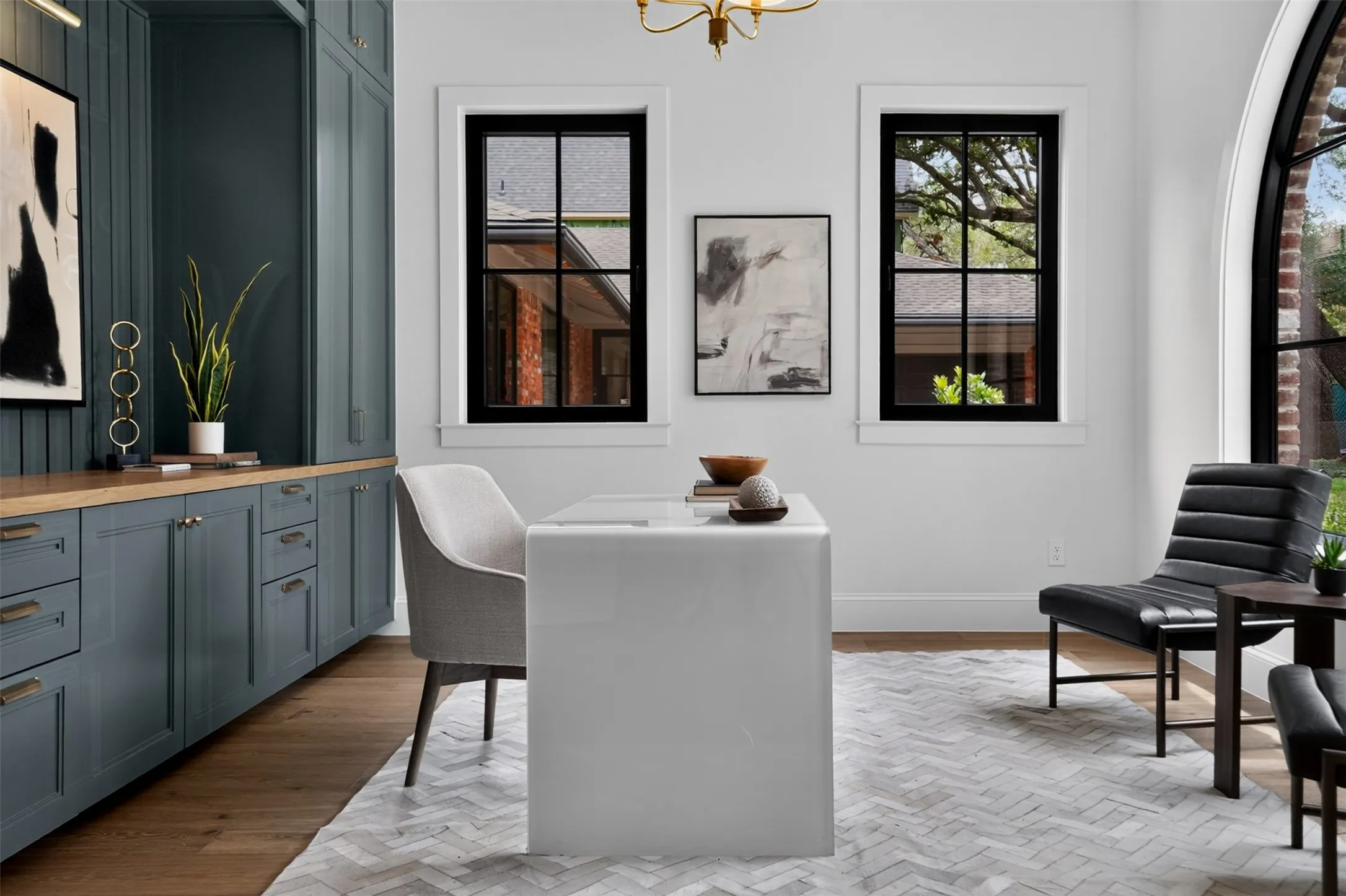 Built-in cabinetry with wood-finish countertop, wood-finish flooring, and black-framed windows