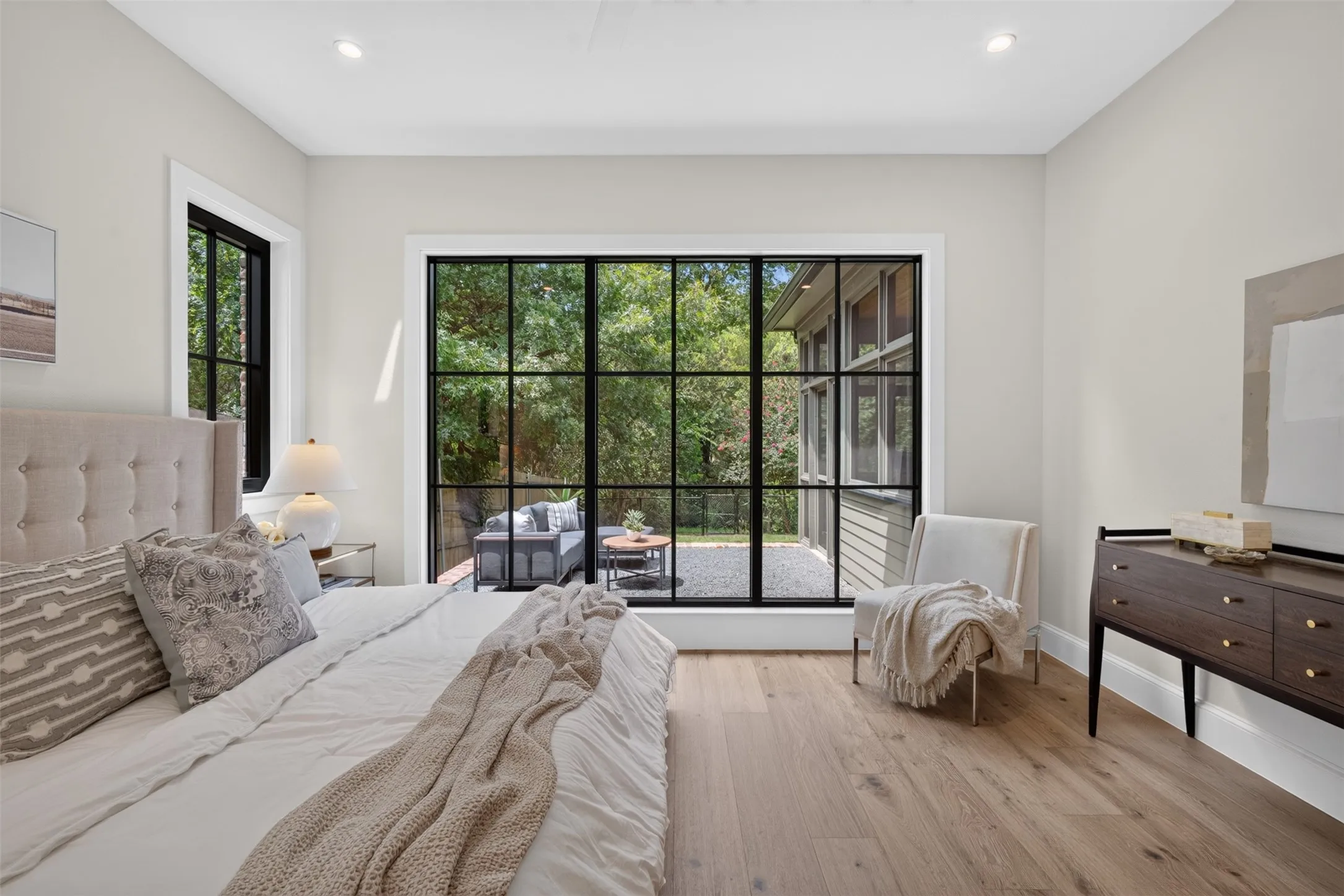 Spacious room featuring light-toned walls and wood-finish flooring
